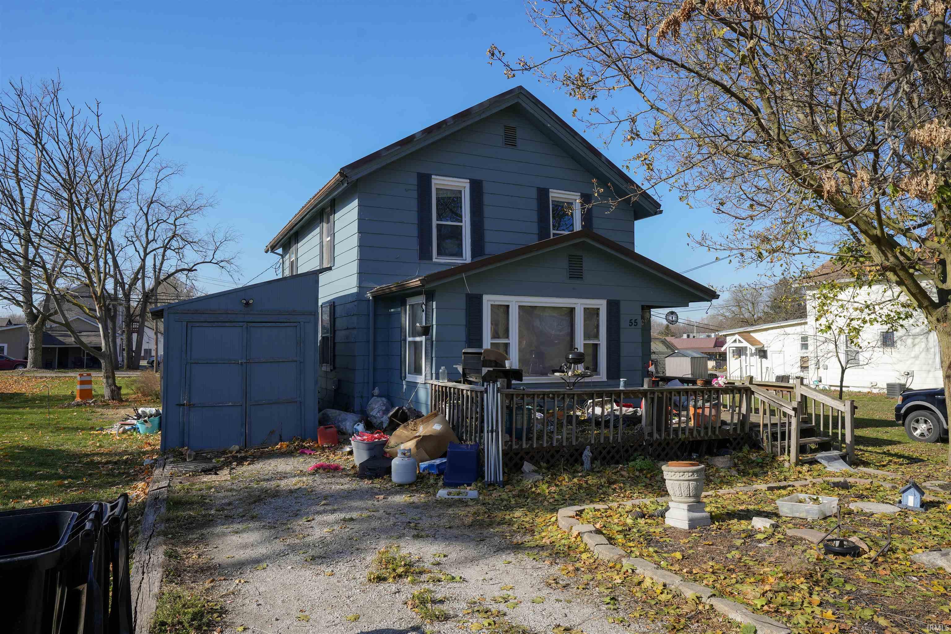 View of front of home featuring a deck and a shed