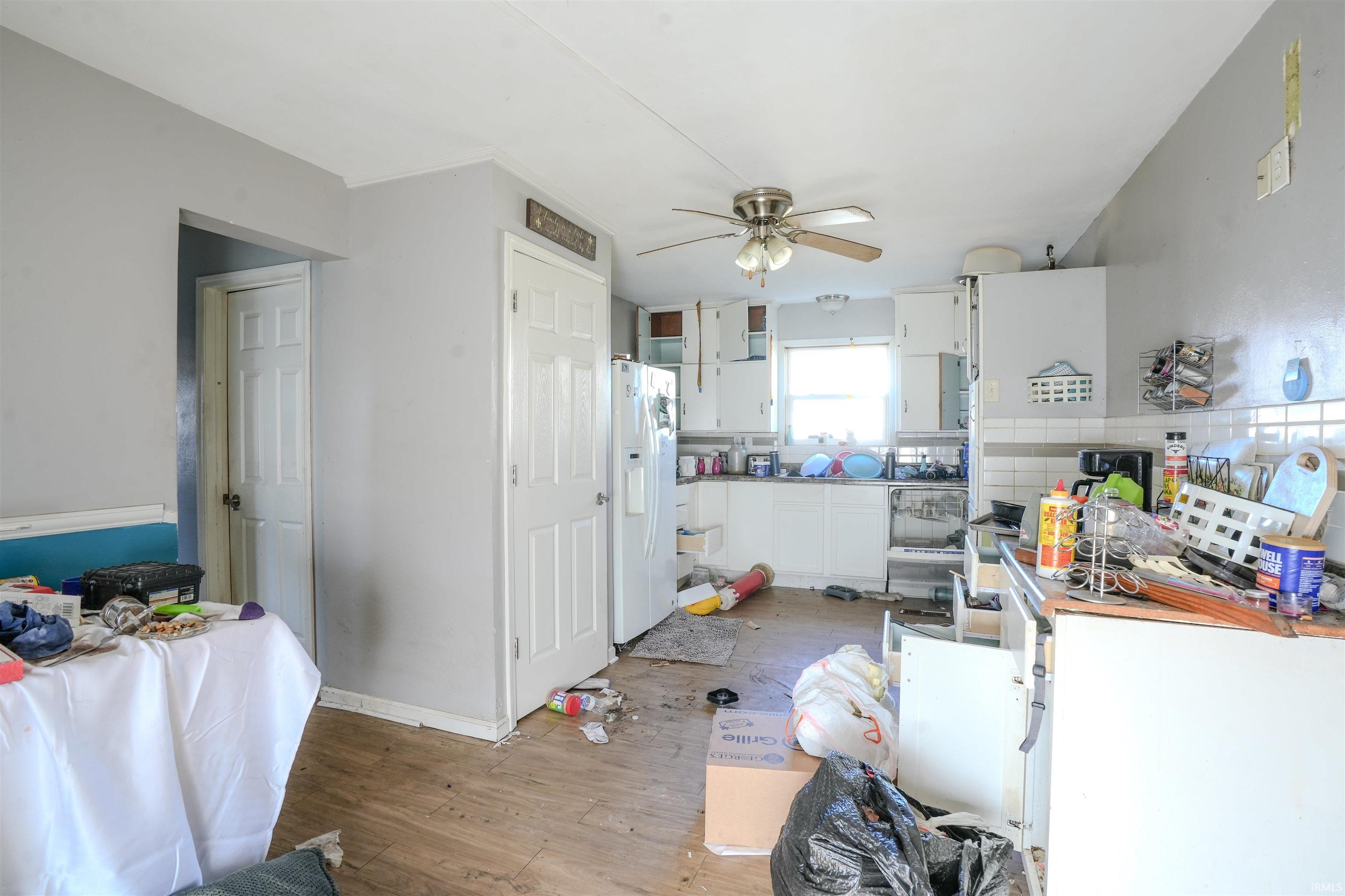 Kitchen with white cabinetry, white refrigerator with ice dispenser, a ceiling fan, light wood-style flooring, and light countertops
