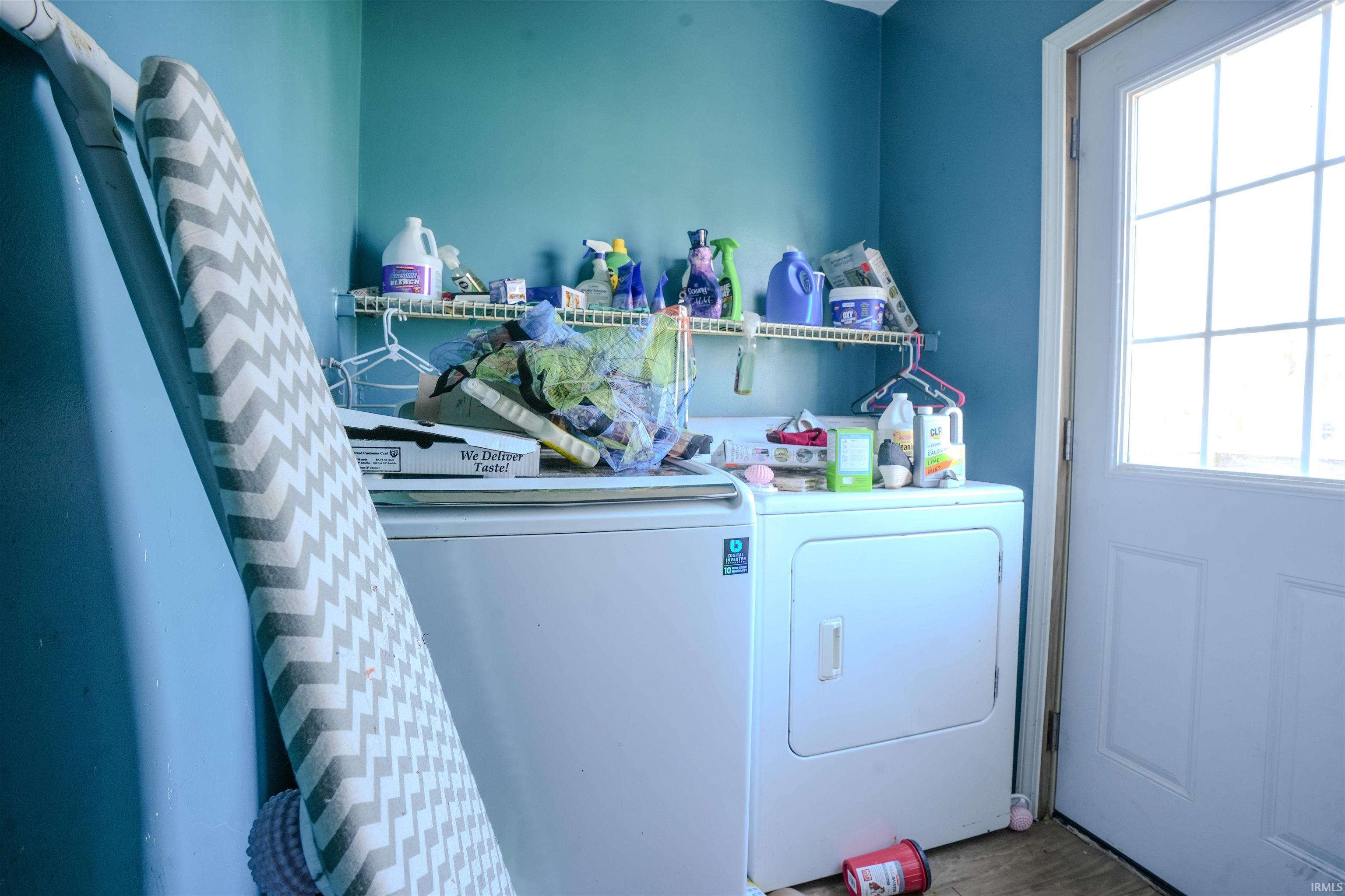 Laundry room featuring washing machine and dryer and wood finished floors