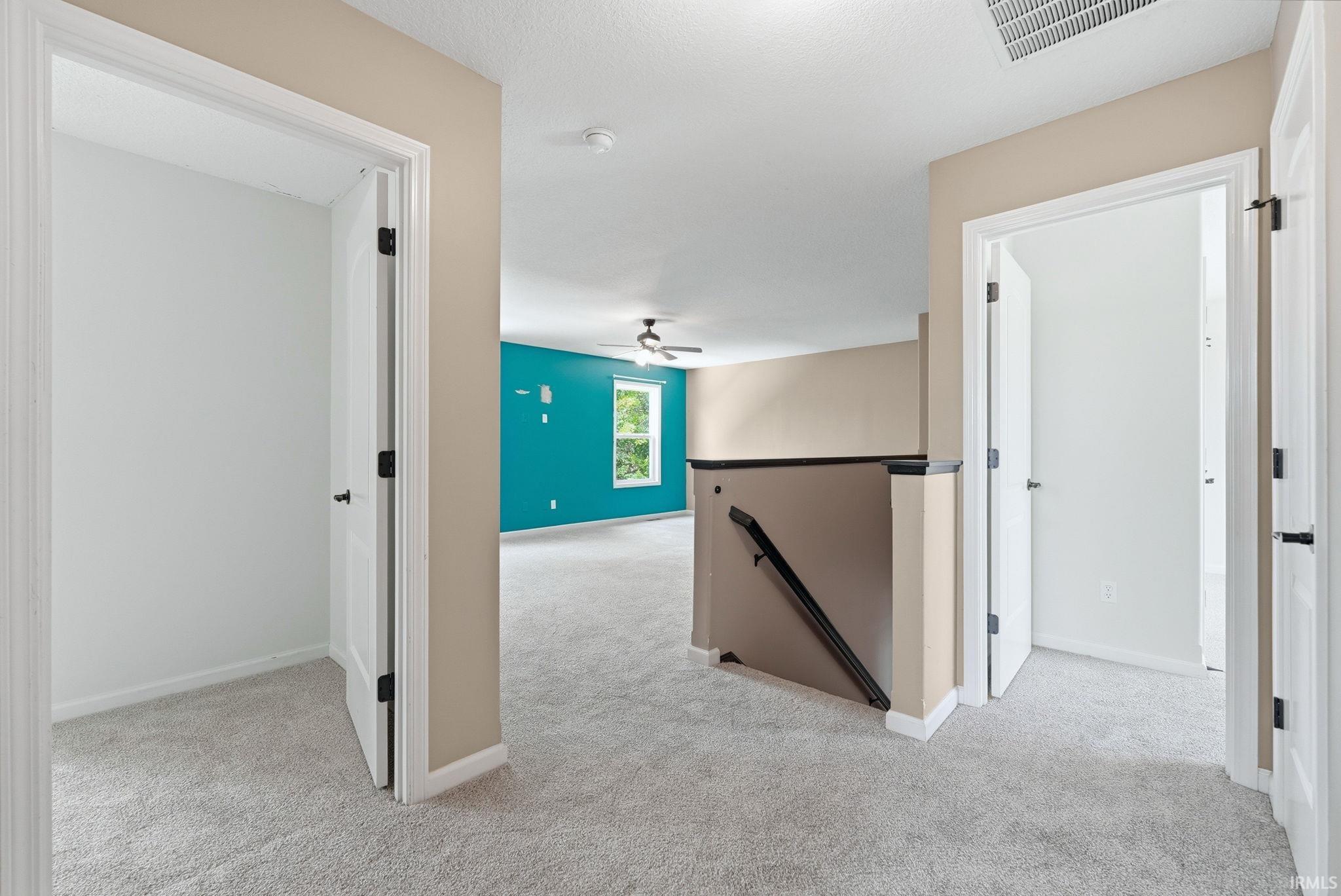 Upper-level landing with plush gray carpeting and neutral wall tones