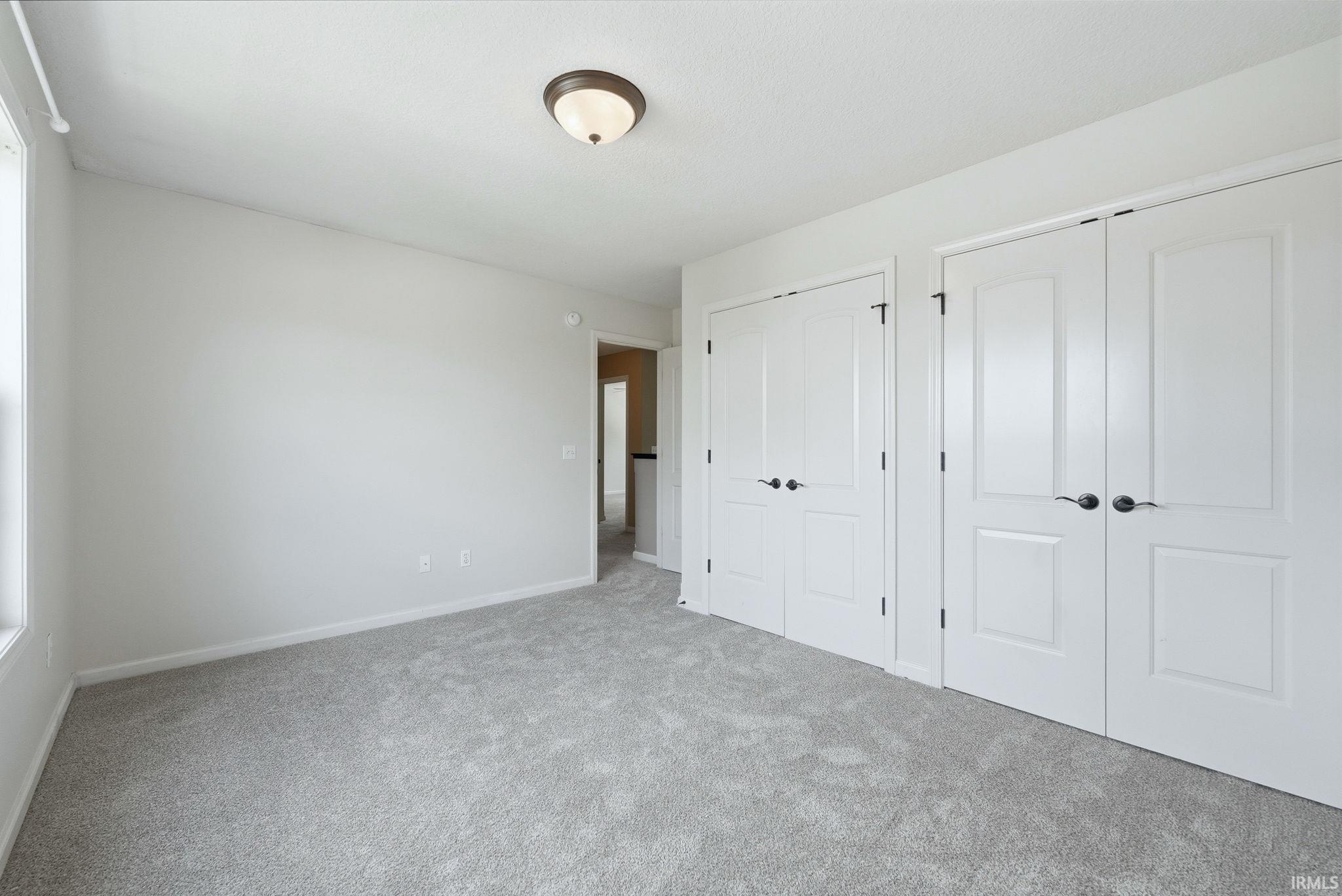 Room featuring light gray carpeting, neutral wall paint, and a semi-flush mount ceiling light