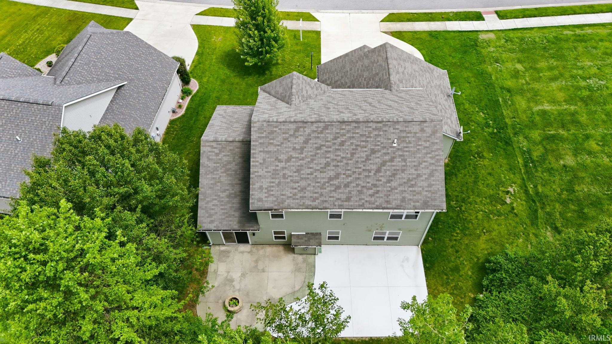 Aerial perspective showcasing the property's exterior, including a multi-gabled roofline, light green siding, and multiple windows