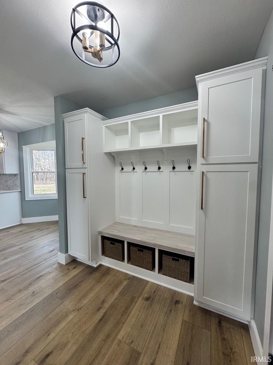Mudroom with a chandelier, light wood-style floors, and a textured ceiling