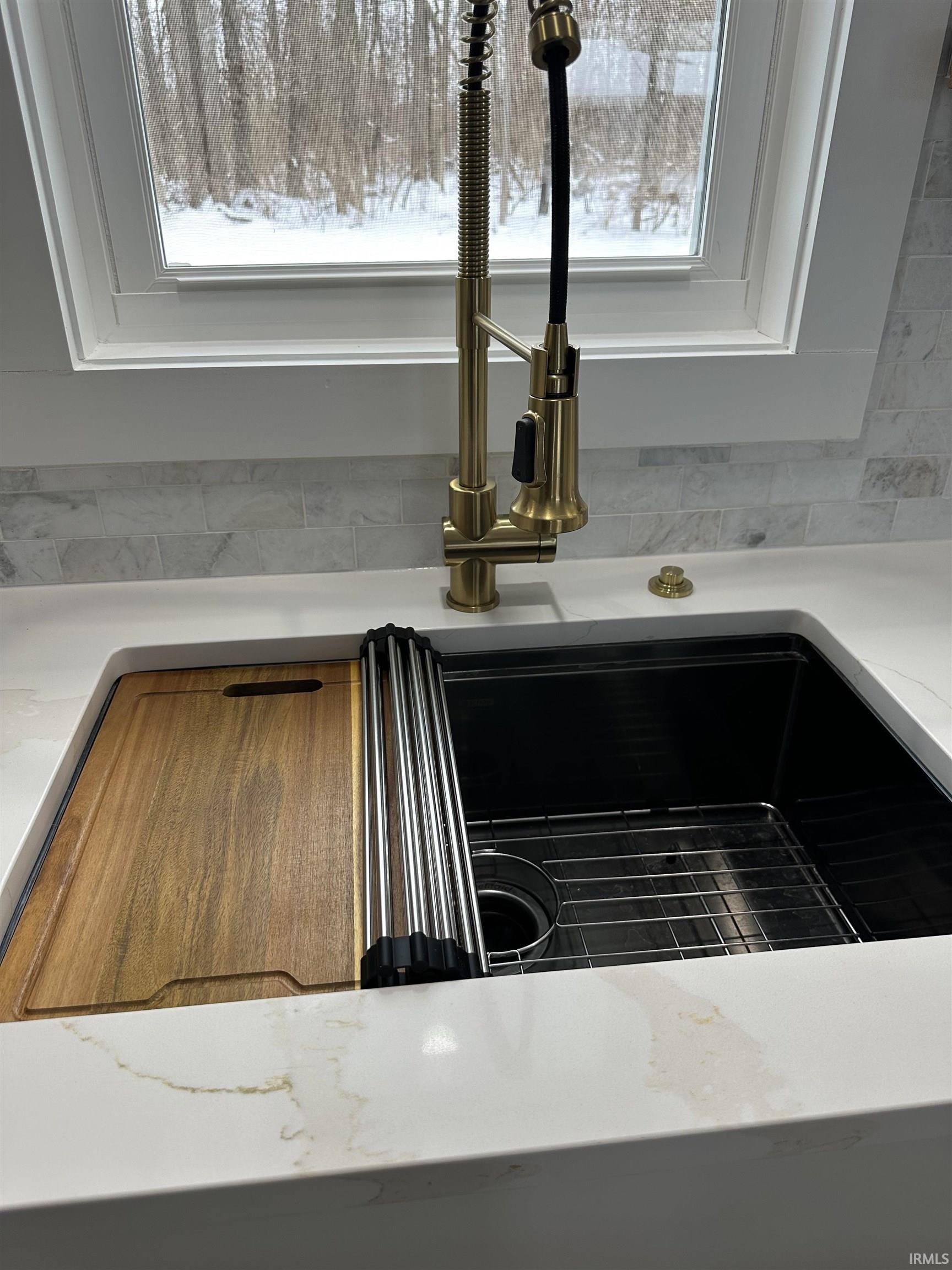Kitchen view of light stone countertops and a sink