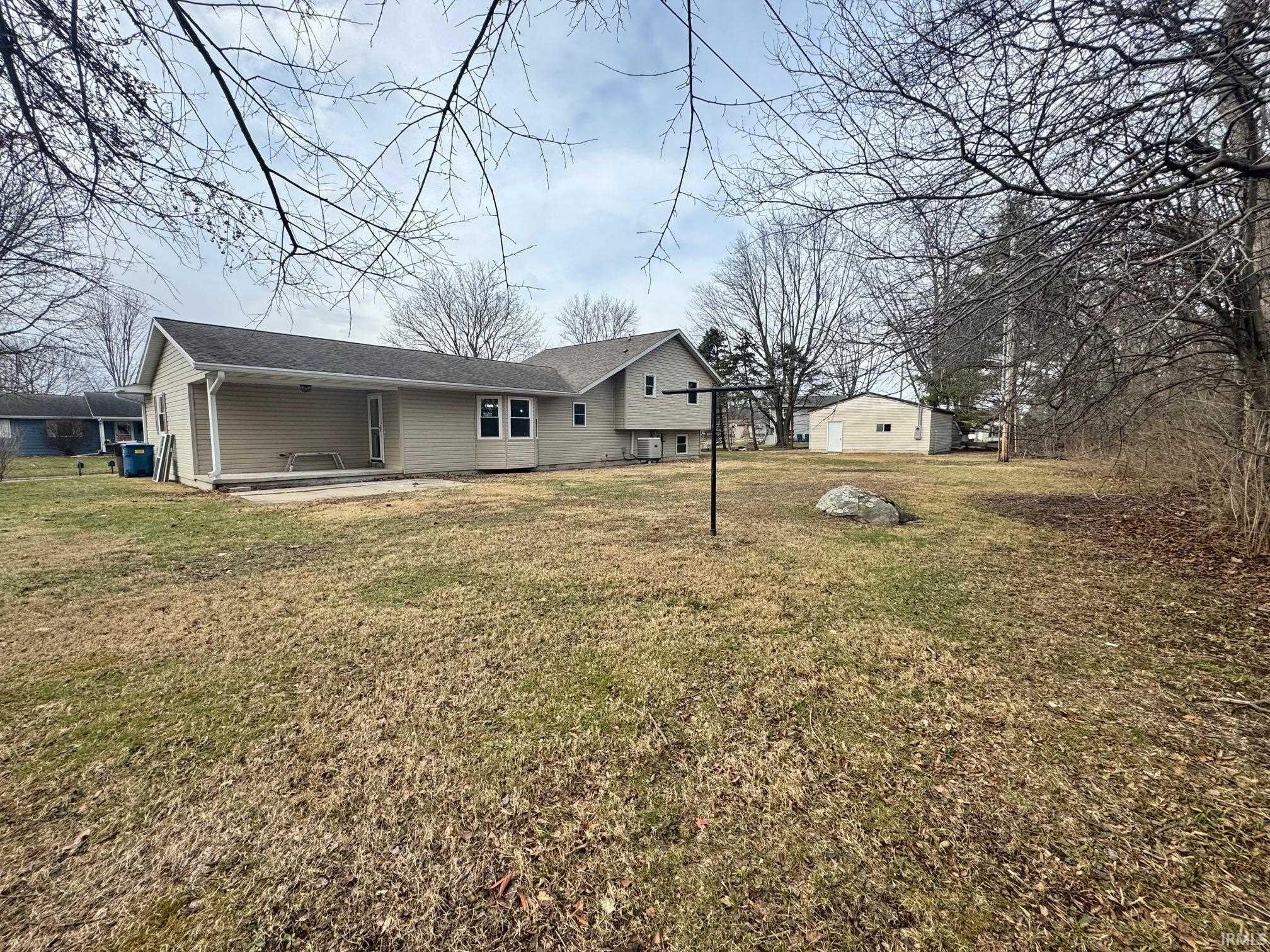 Rear view of property with a yard and a patio