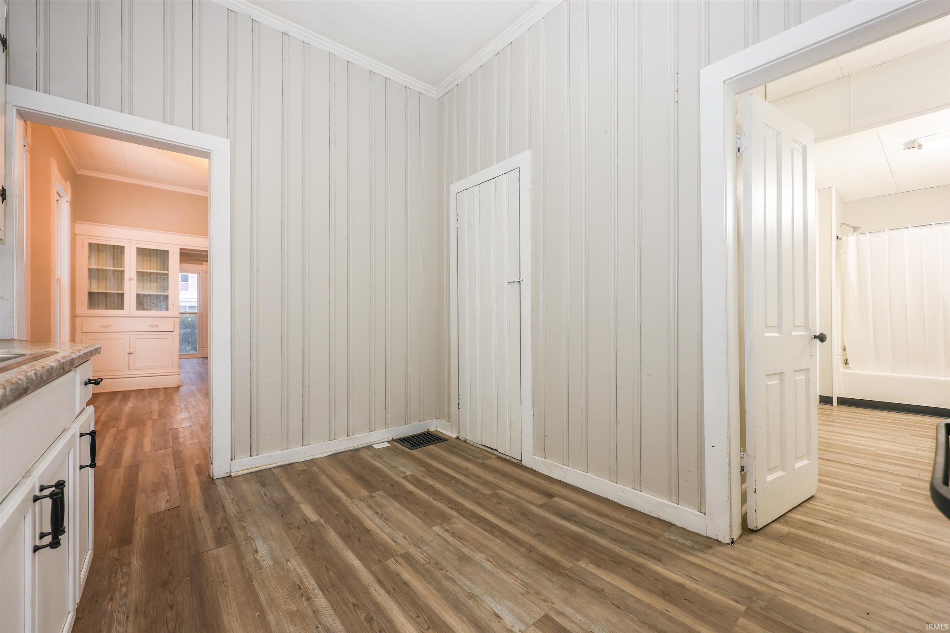 Unfurnished dining area featuring crown molding and light wood-style floors