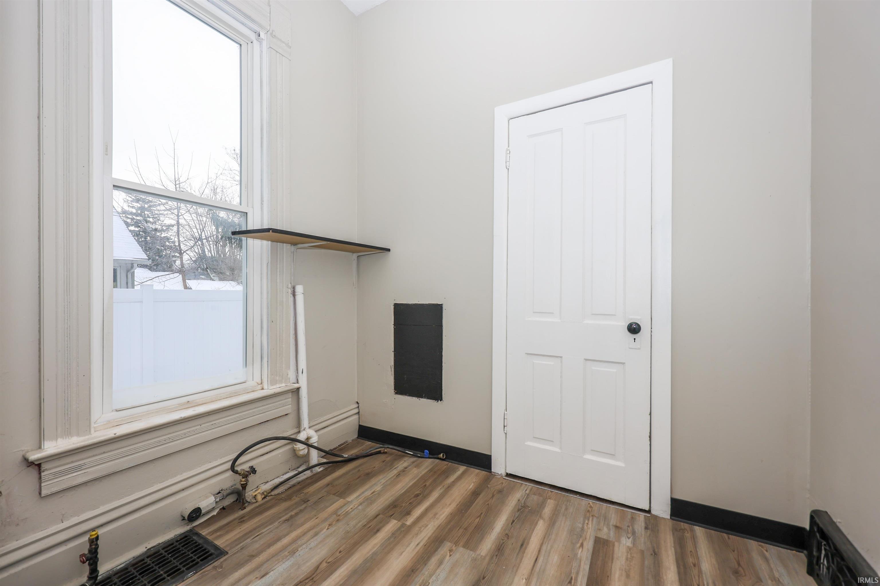 Spare room featuring baseboards and light wood-style floors
