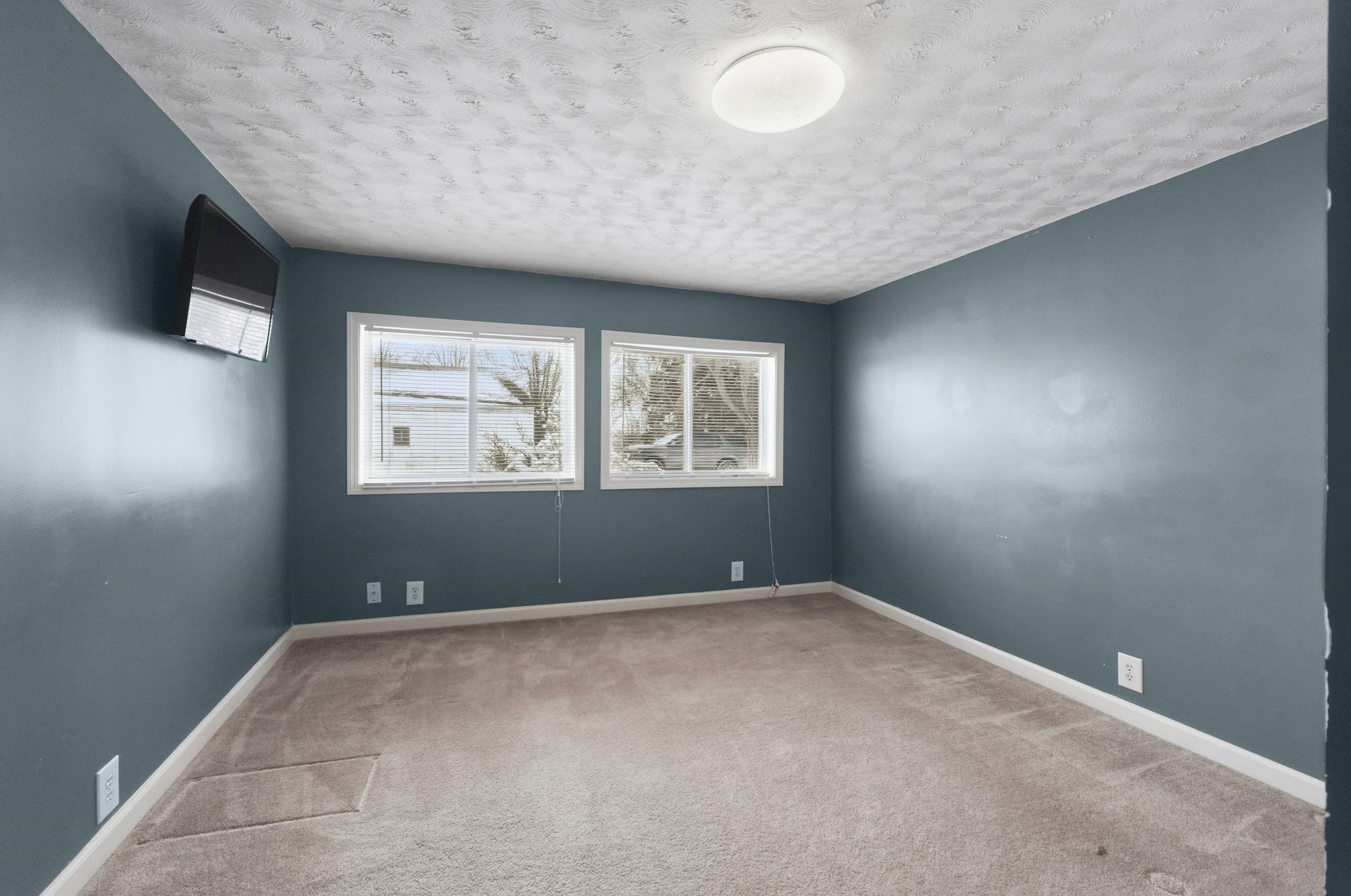Unfurnished room with light colored carpet and a textured ceiling
