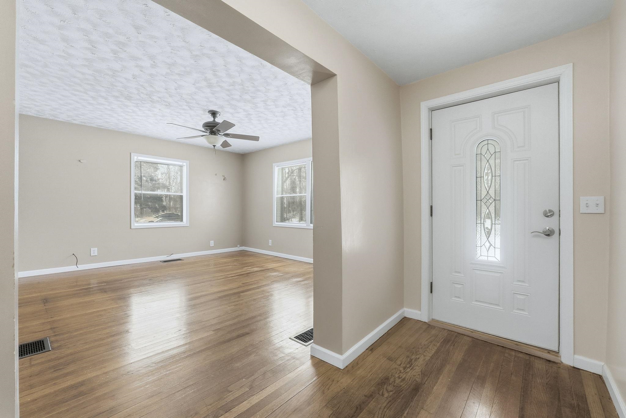 Entrance foyer featuring hardwood / wood-style flooring, a ceiling fan, and a textured ceiling