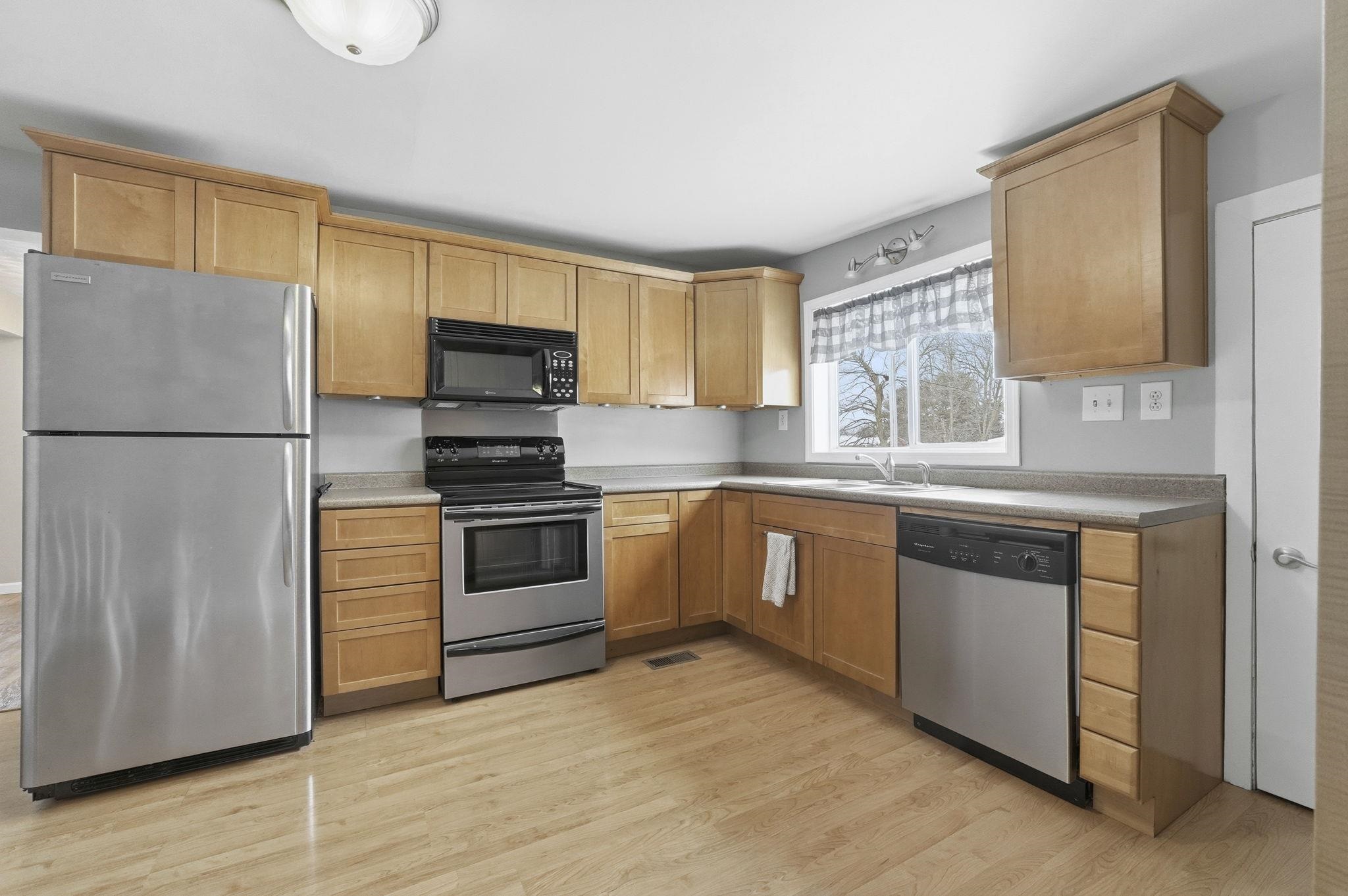 Kitchen featuring appliances with stainless steel finishes, light wood-type flooring, and light countertops