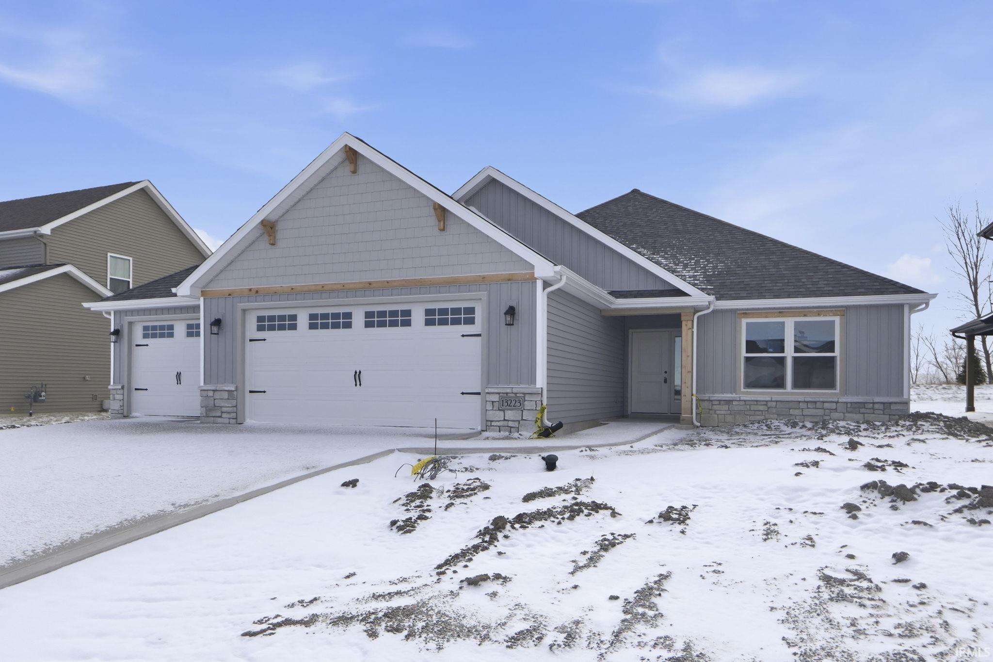 Craftsman-style house featuring stone siding and a garage