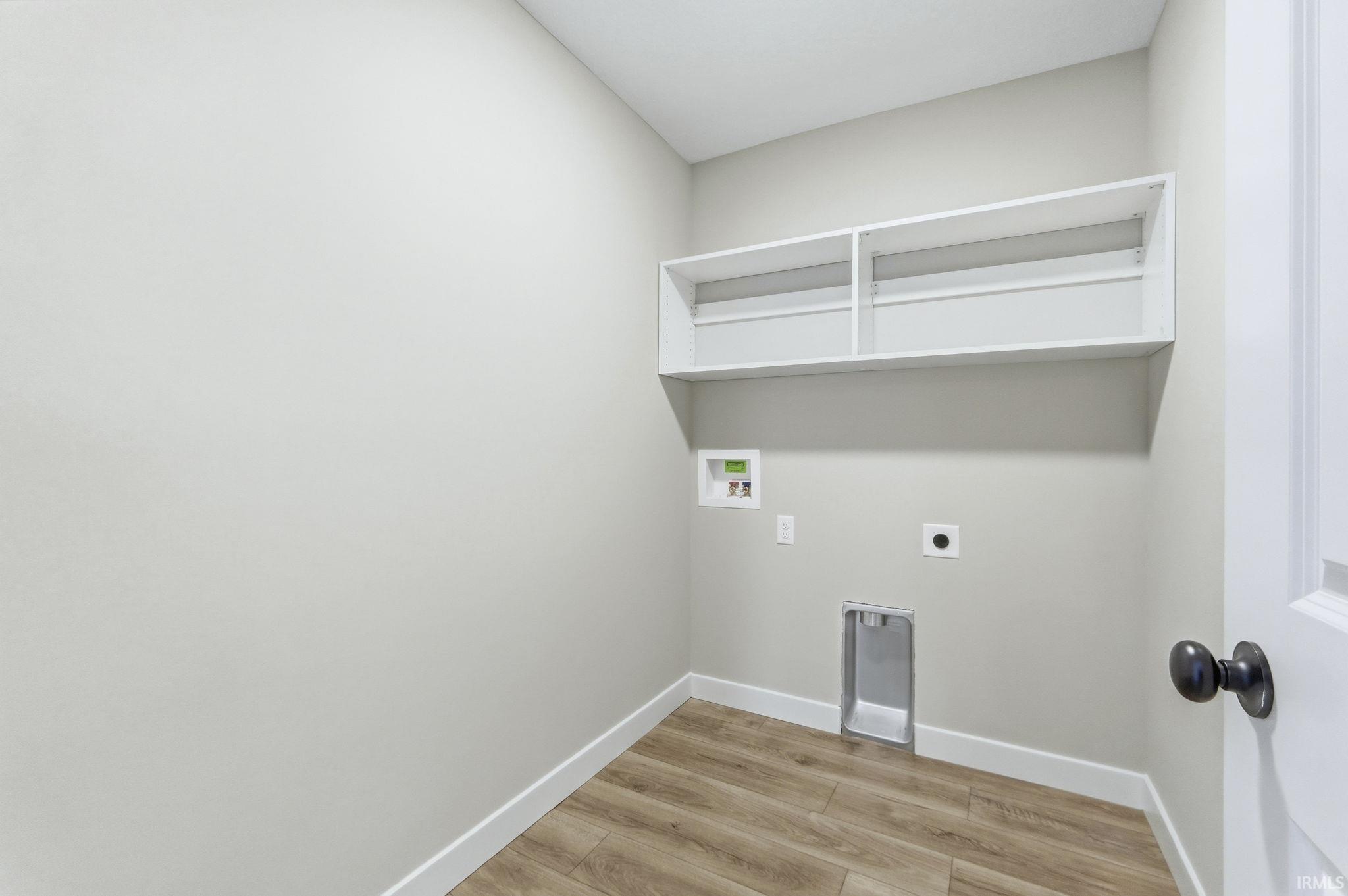 Laundry area with light wood-style flooring, hookup for an electric dryer, and washer hookup