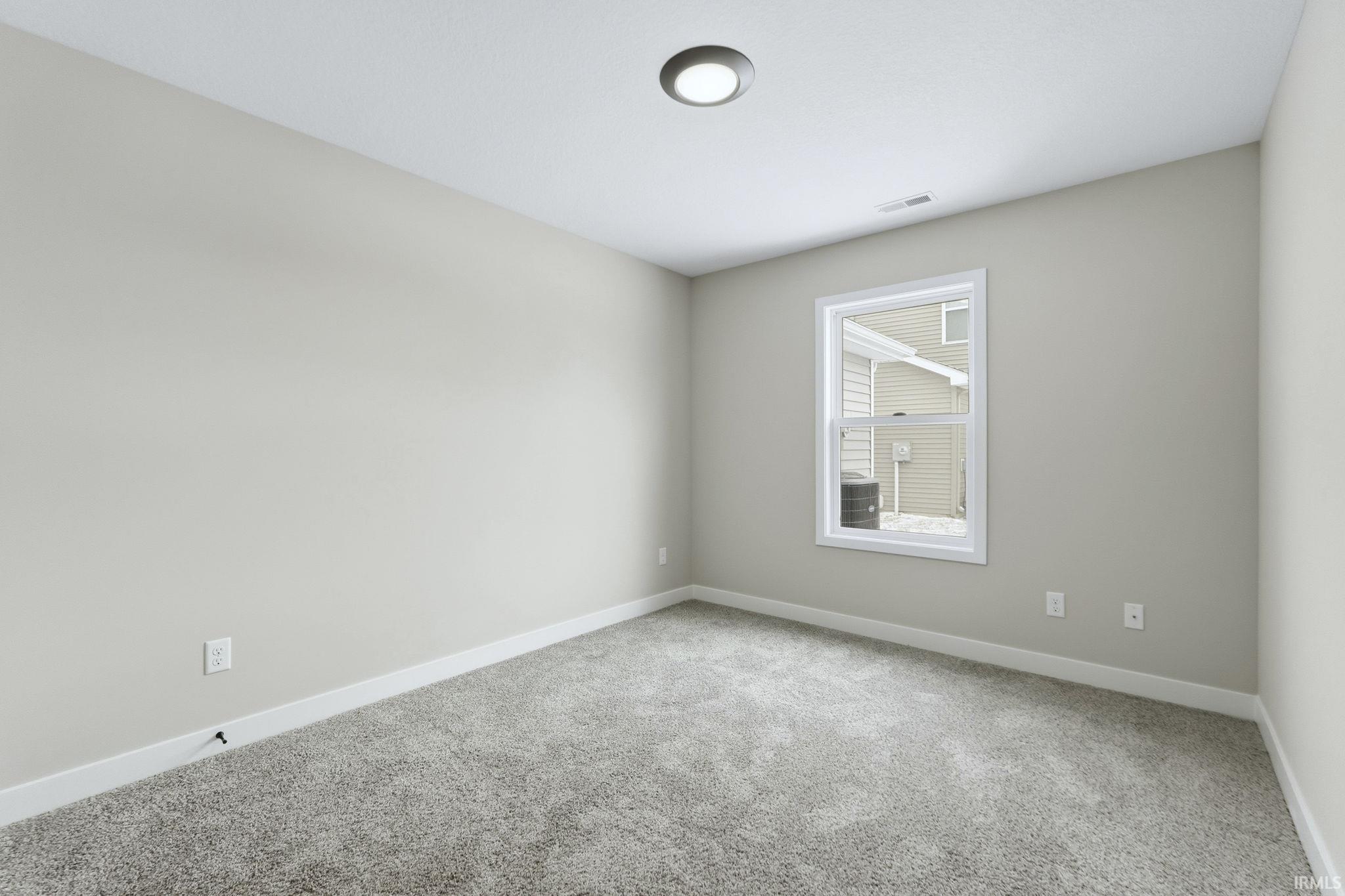 Carpeted empty room with baseboards