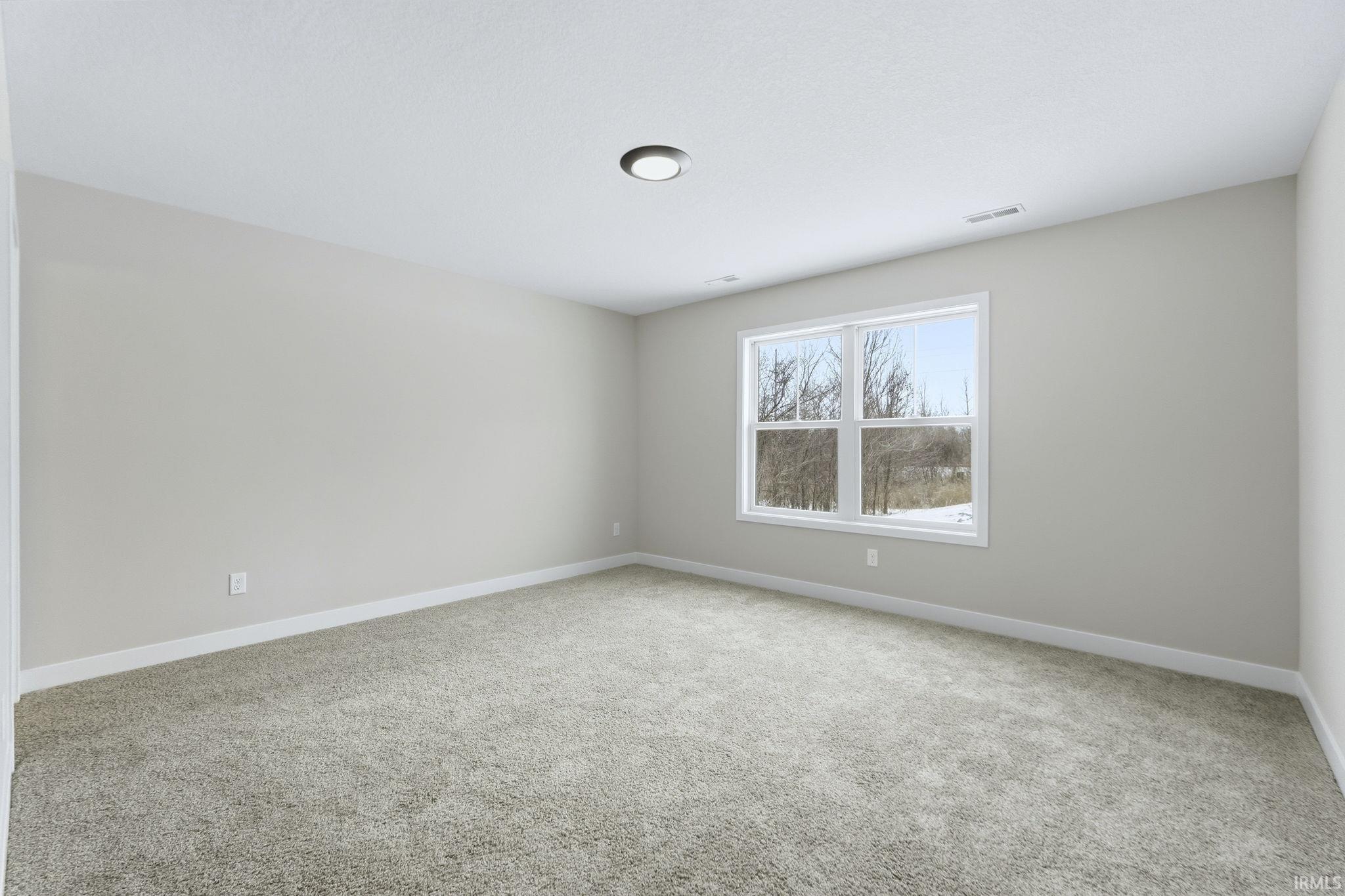 Unfurnished room with light colored carpet and baseboards