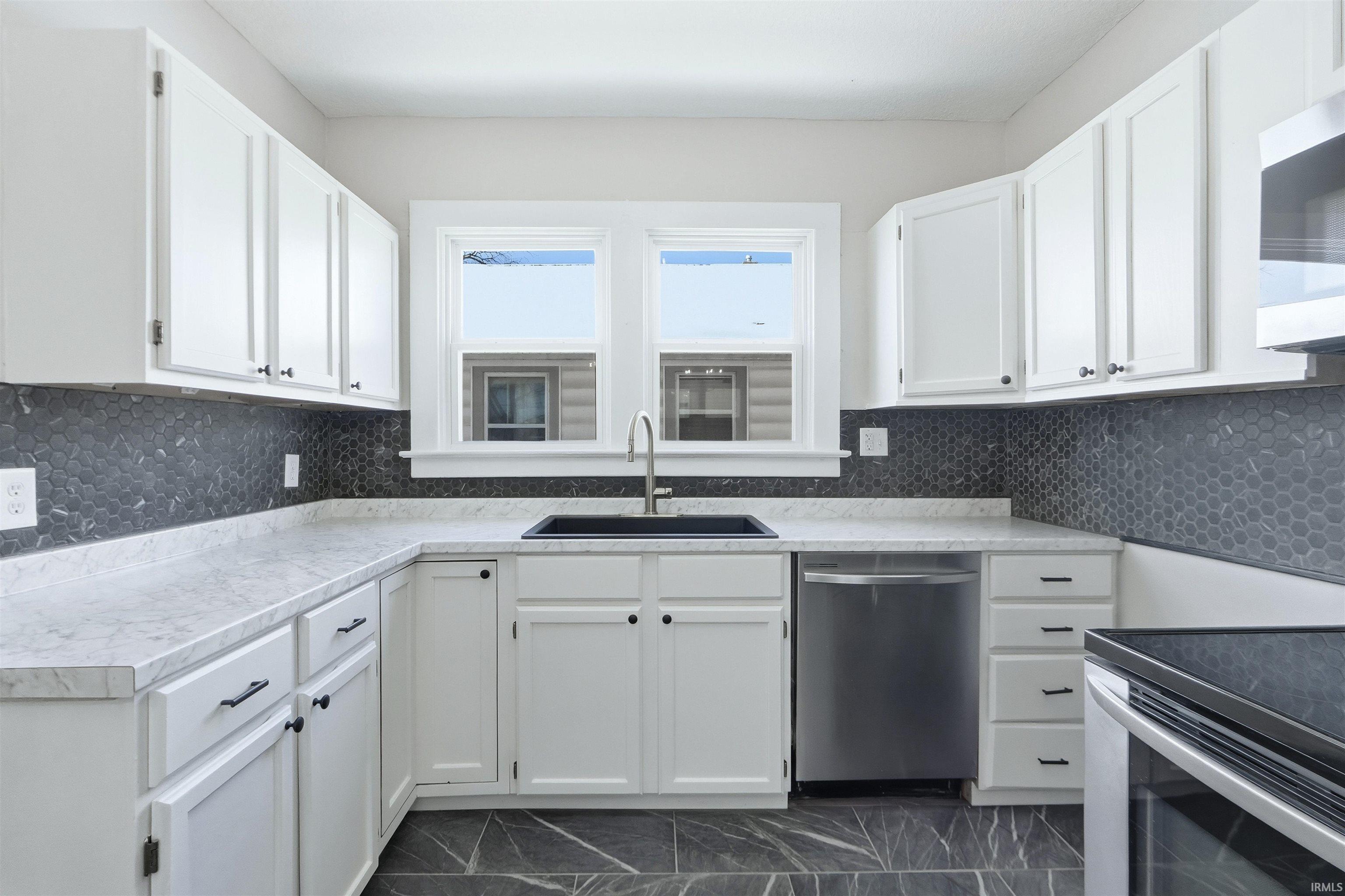 Kitchen featuring white cabinetry and decorative backsplash