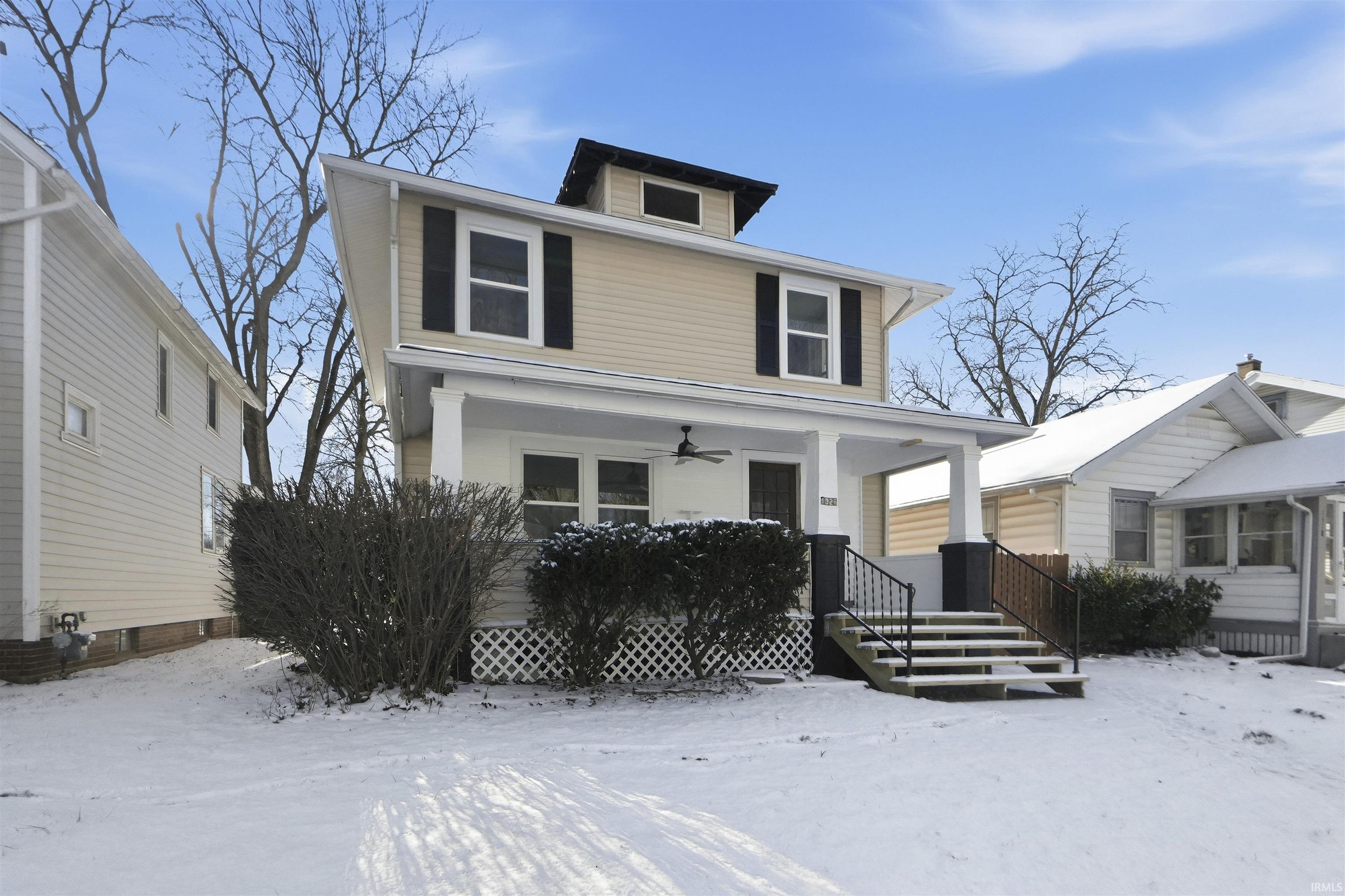 American foursquare style home featuring a porch and ceiling fan