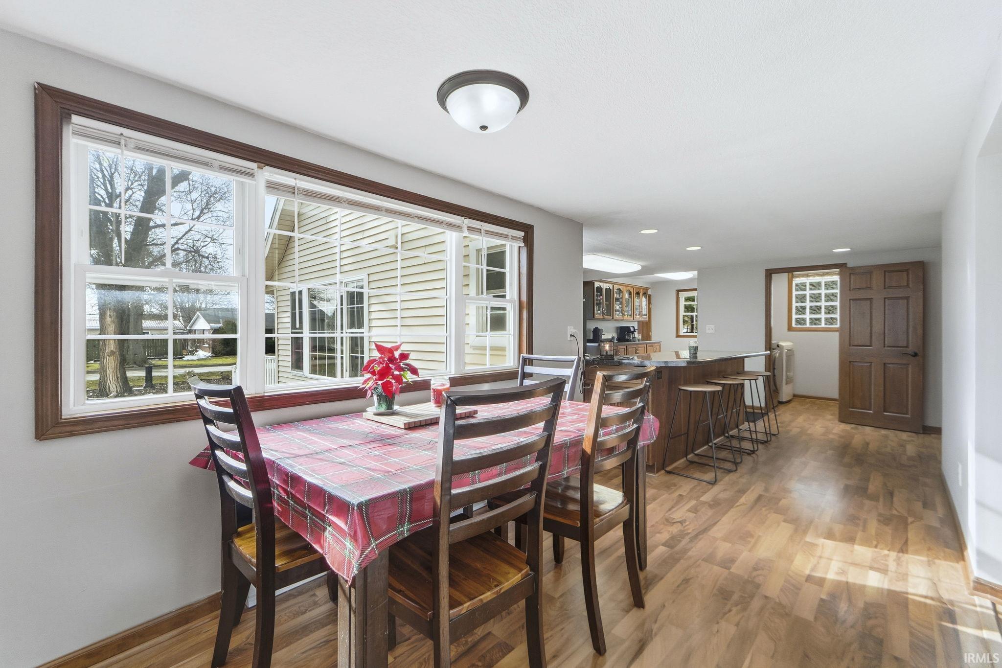 Dining space featuring light wood finished floors, bar, and recessed lighting