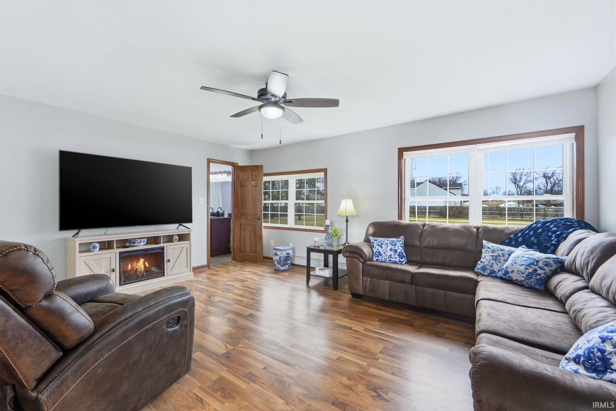 Living area with wood finished floors and ceiling fan