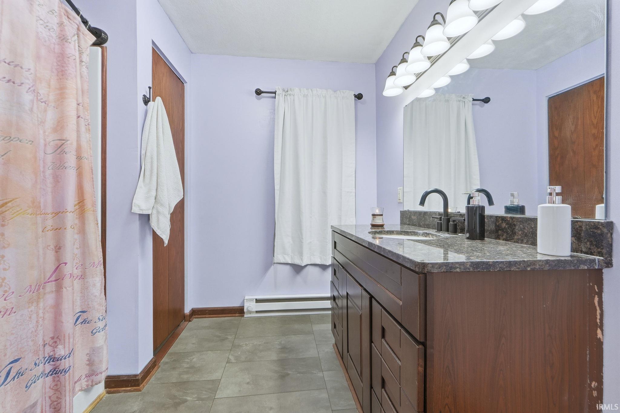 Full bathroom with vanity and baseboard heating