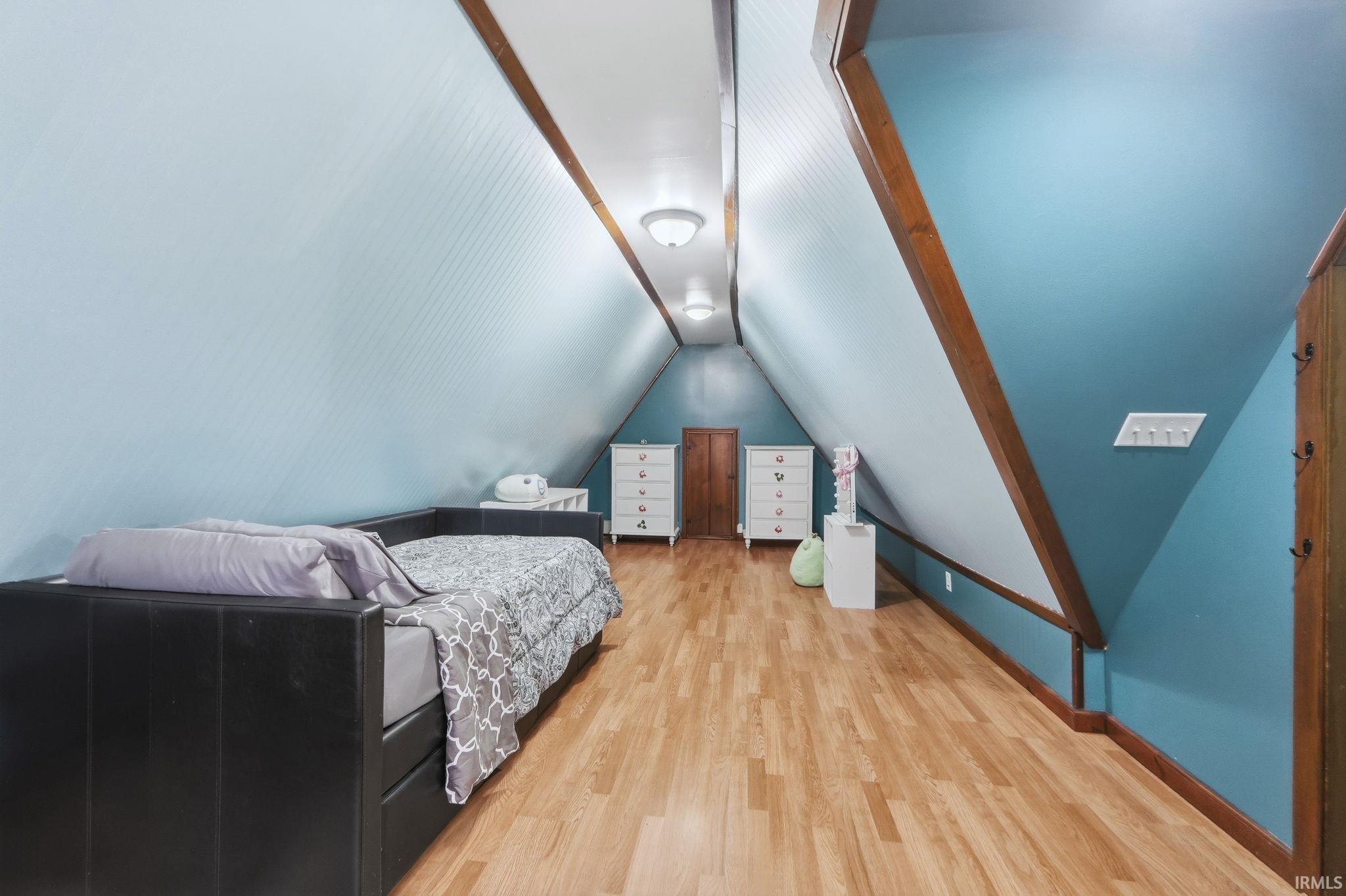 Bedroom featuring lofted ceiling and light wood finished floors