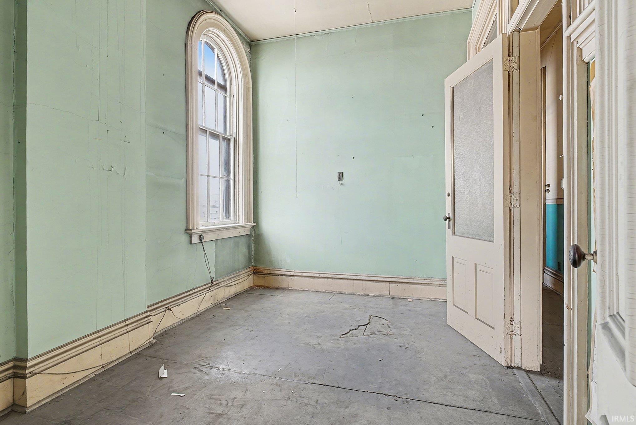 Spare room featuring plenty of natural light and unfinished concrete flooring
