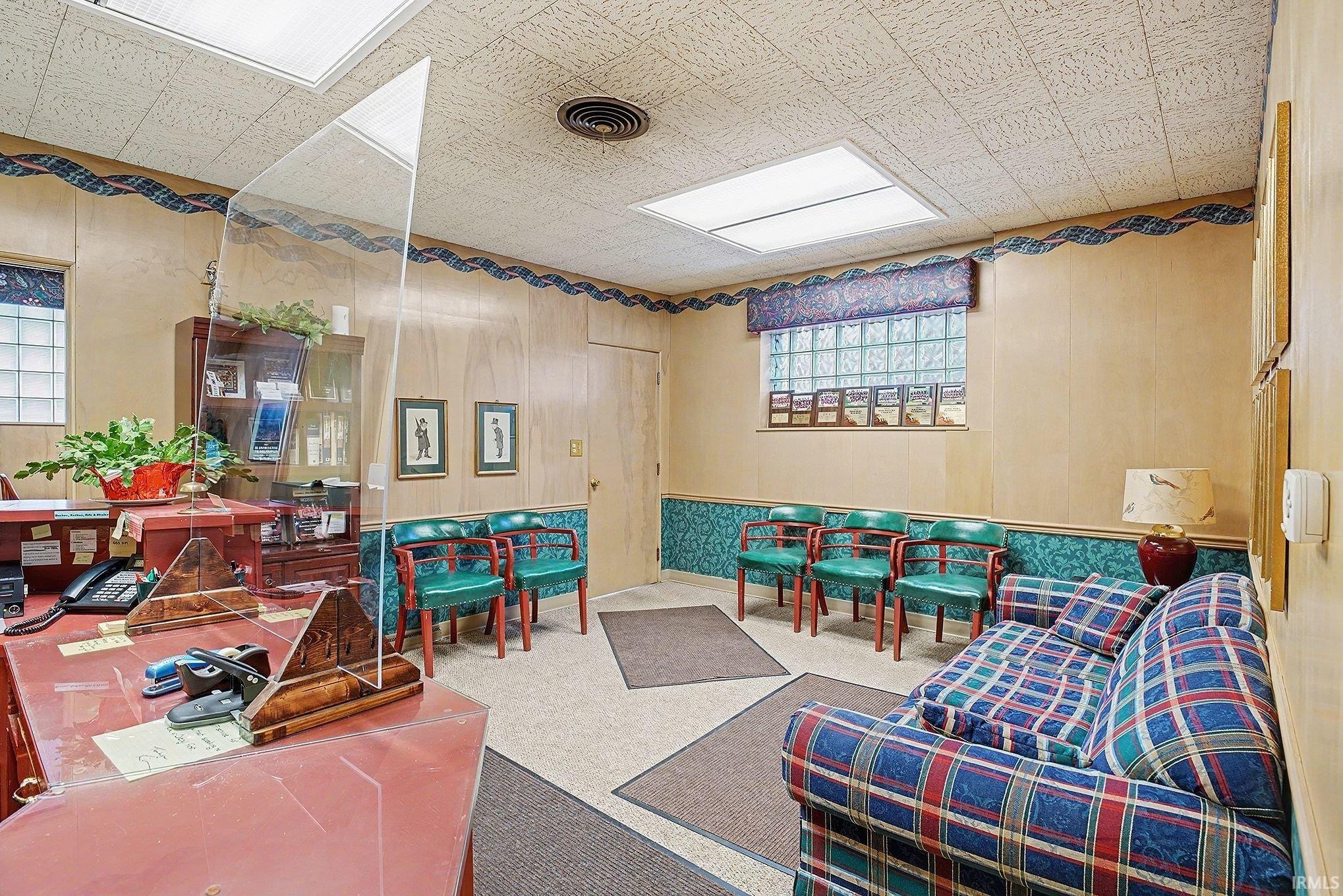 Home office with wood walls, a wainscoted wall, and carpet flooring