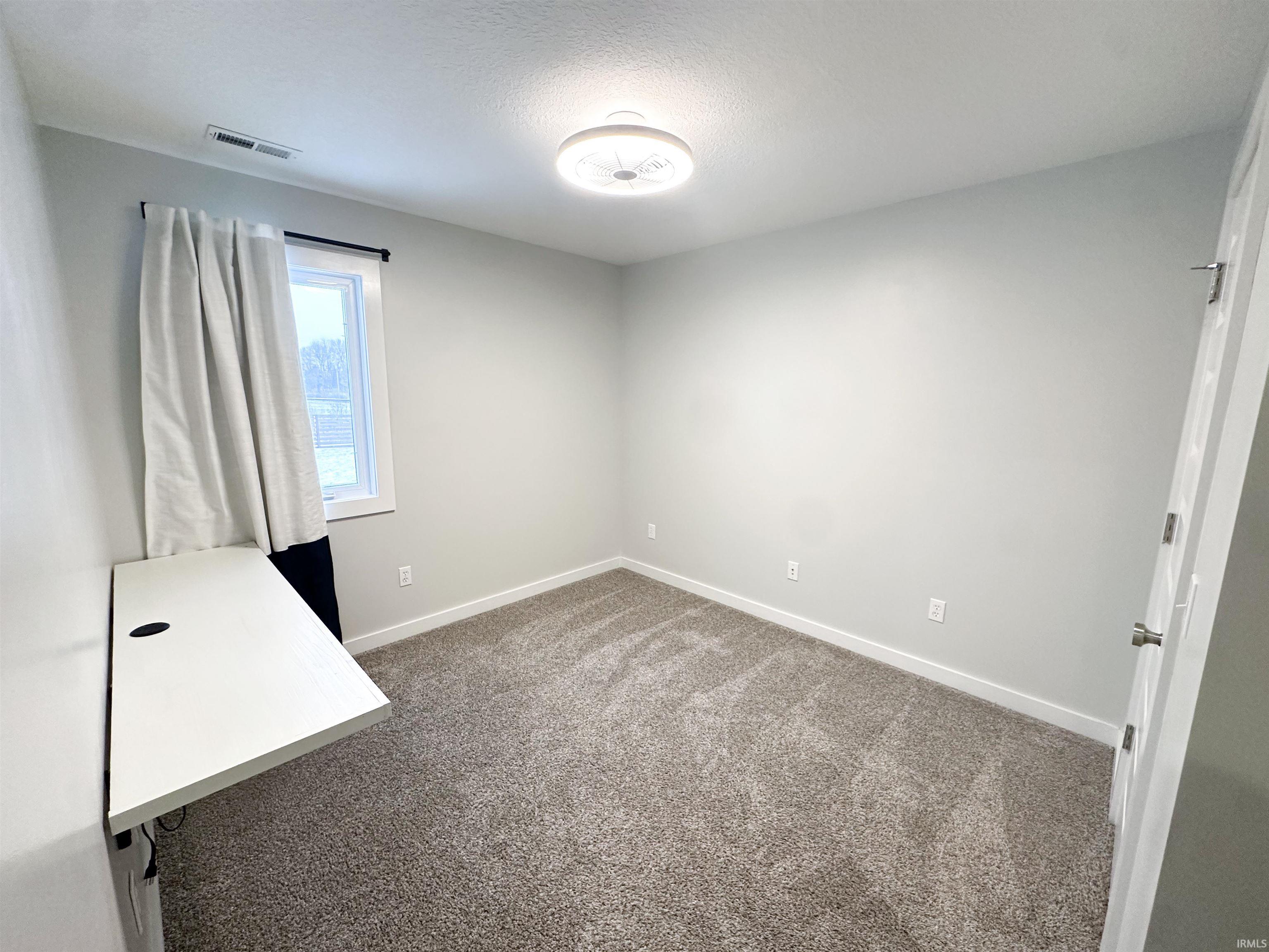 Unfurnished bedroom featuring carpet flooring and a textured ceiling