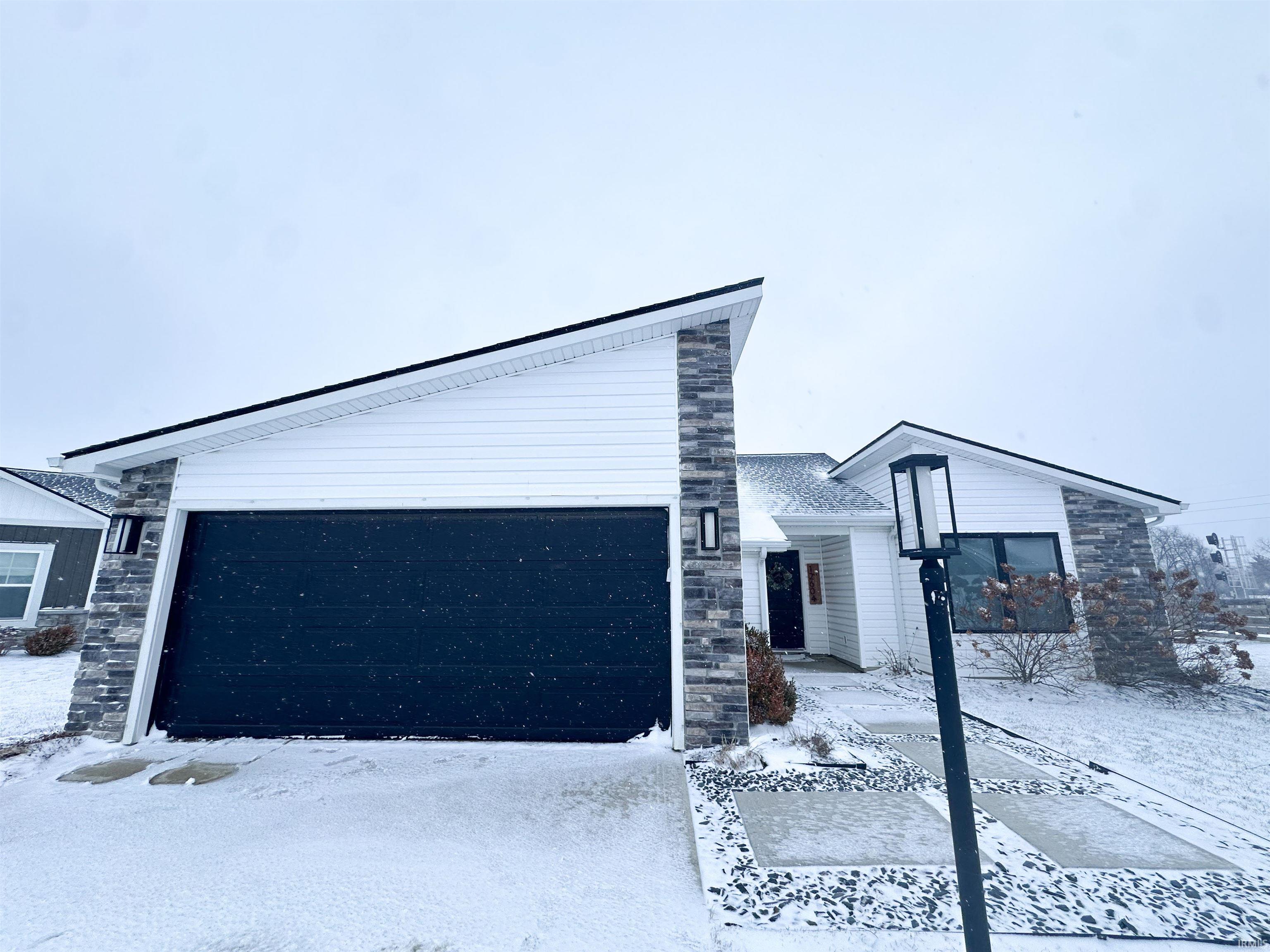 View of front of property featuring stone siding and driveway