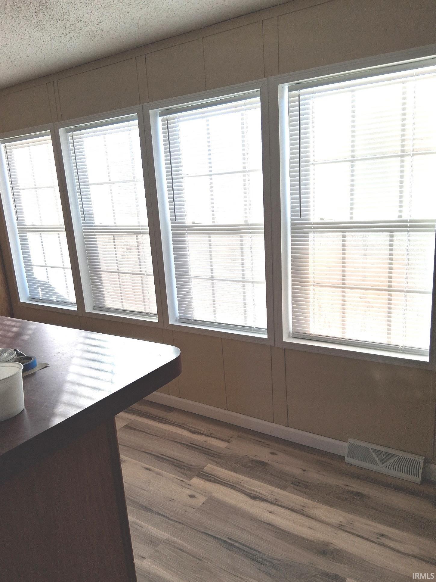 Dining room featuring a textured ceiling, new vinyl plank  flooring, and healthy amount of natural light
