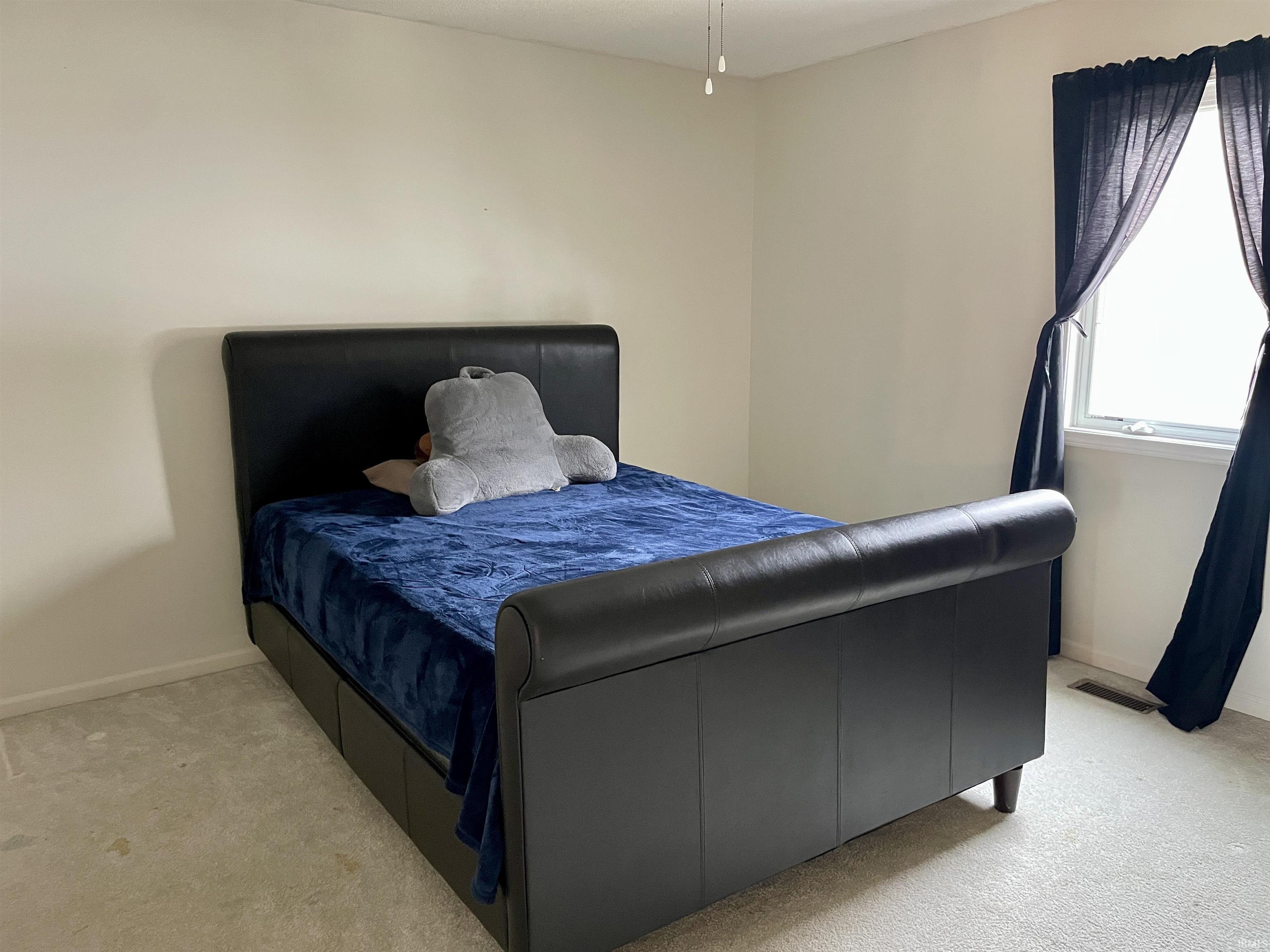 Bedroom featuring light colored carpet and baseboards