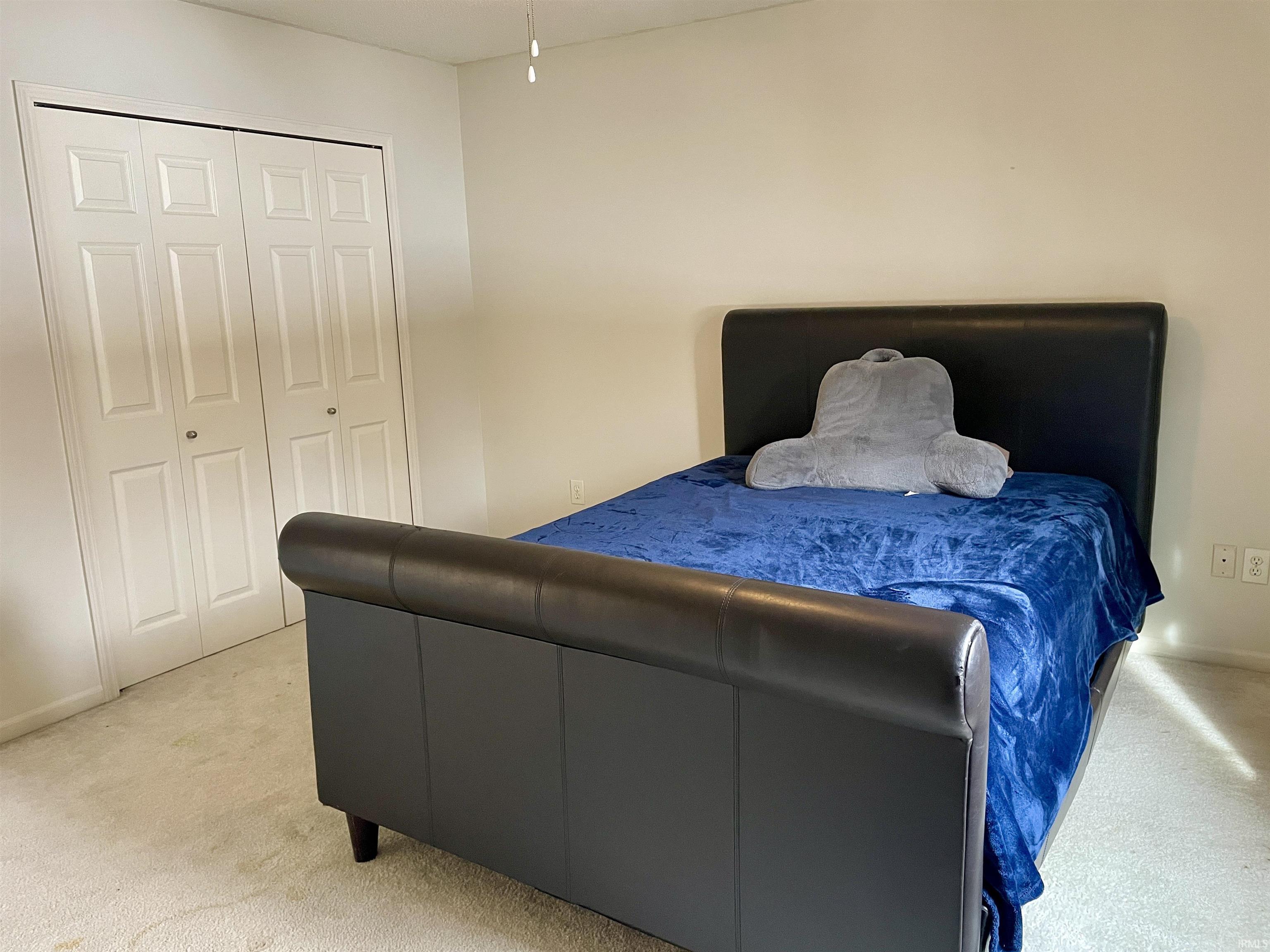 Bedroom featuring carpet flooring and a closet