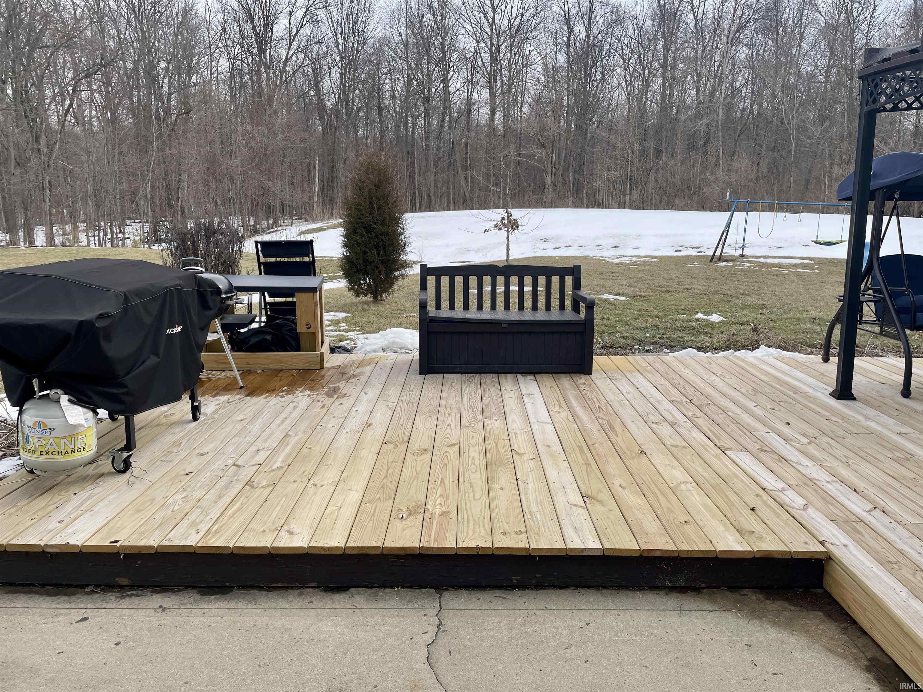 Wooden terrace with a grill and a playground
