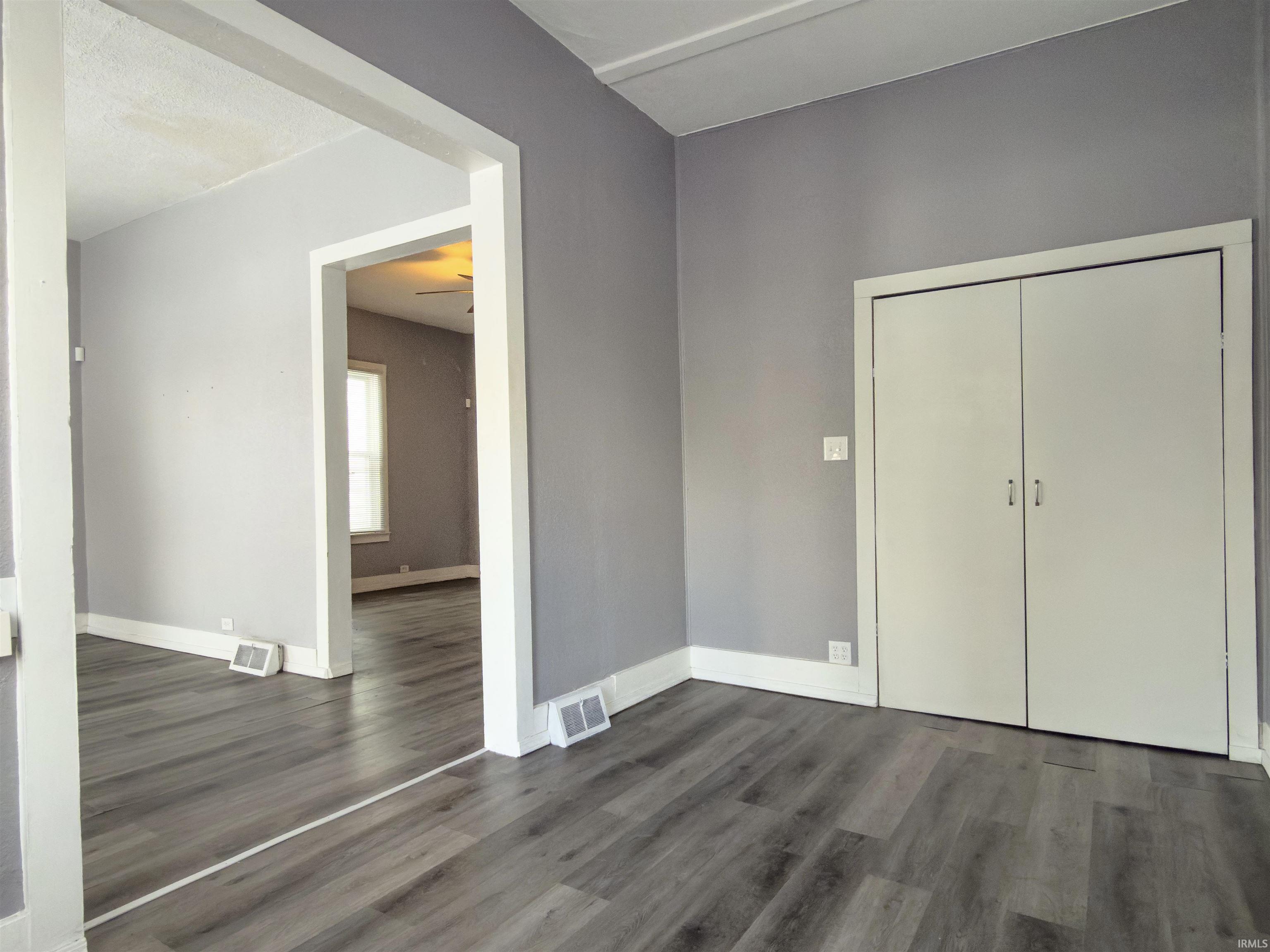 Unfurnished bedroom featuring dark wood-type flooring and a closet