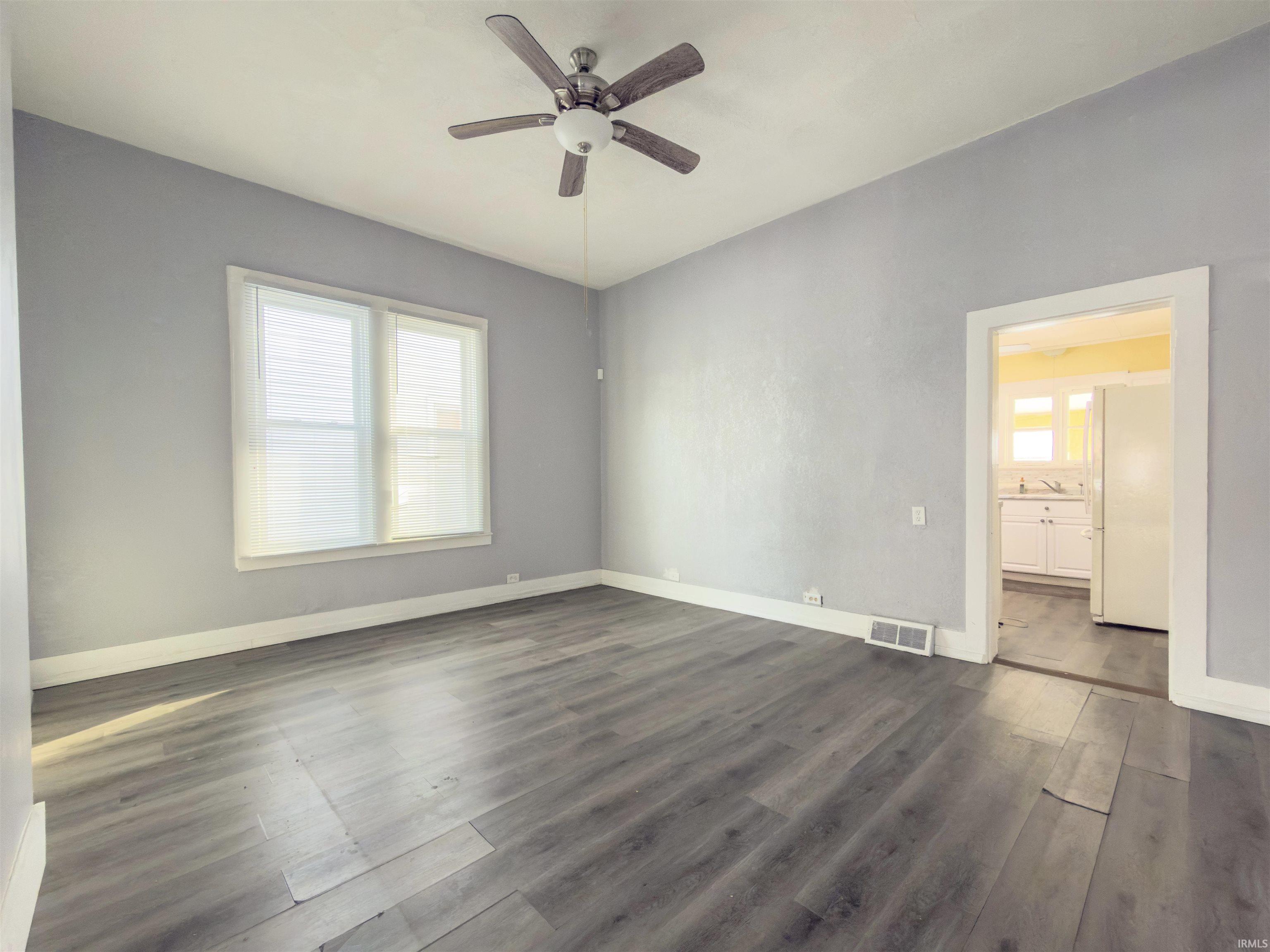 Unfurnished room with dark wood finished floors and a ceiling fan