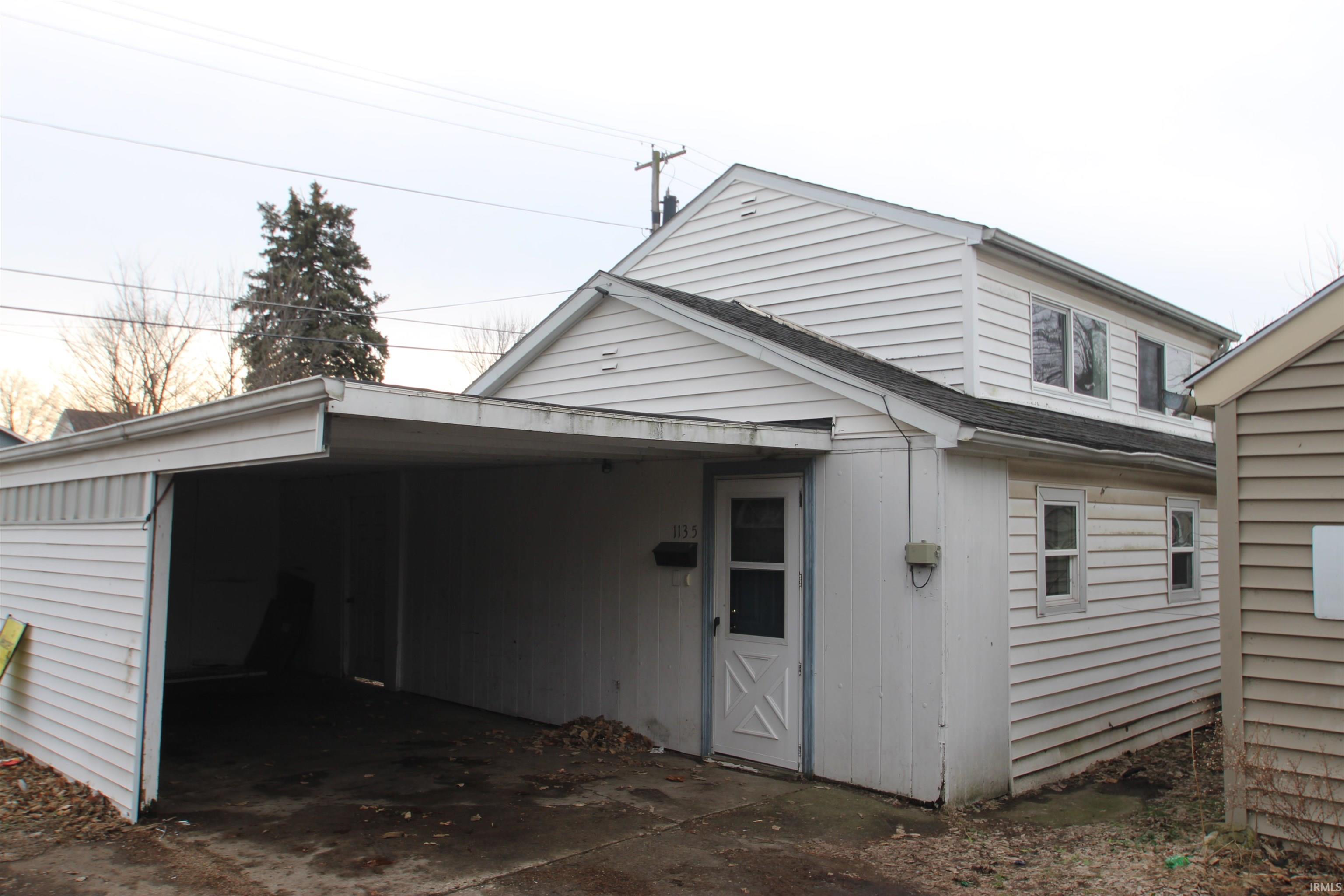 View of side of home featuring roof with shingles