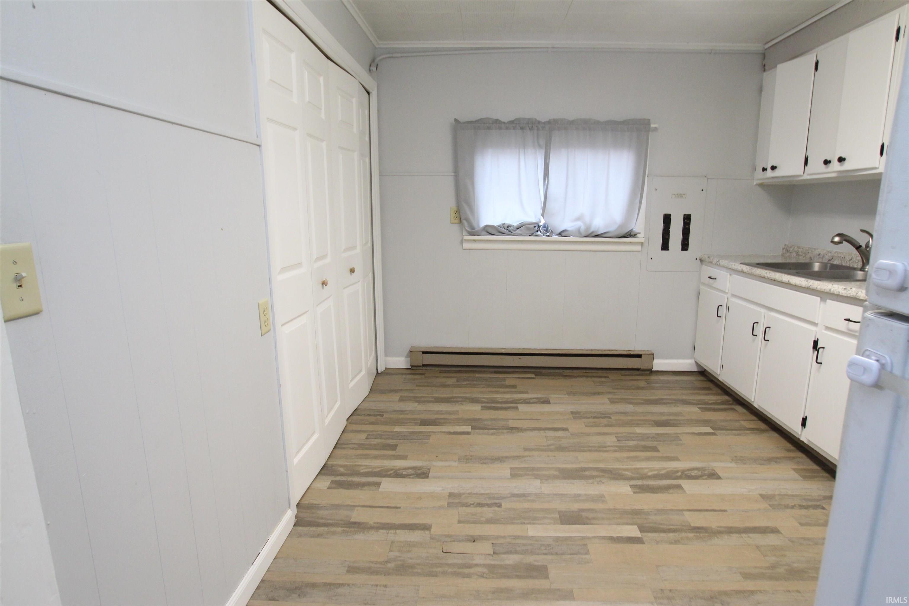 Laundry room featuring baseboard heating and light wood-style flooring