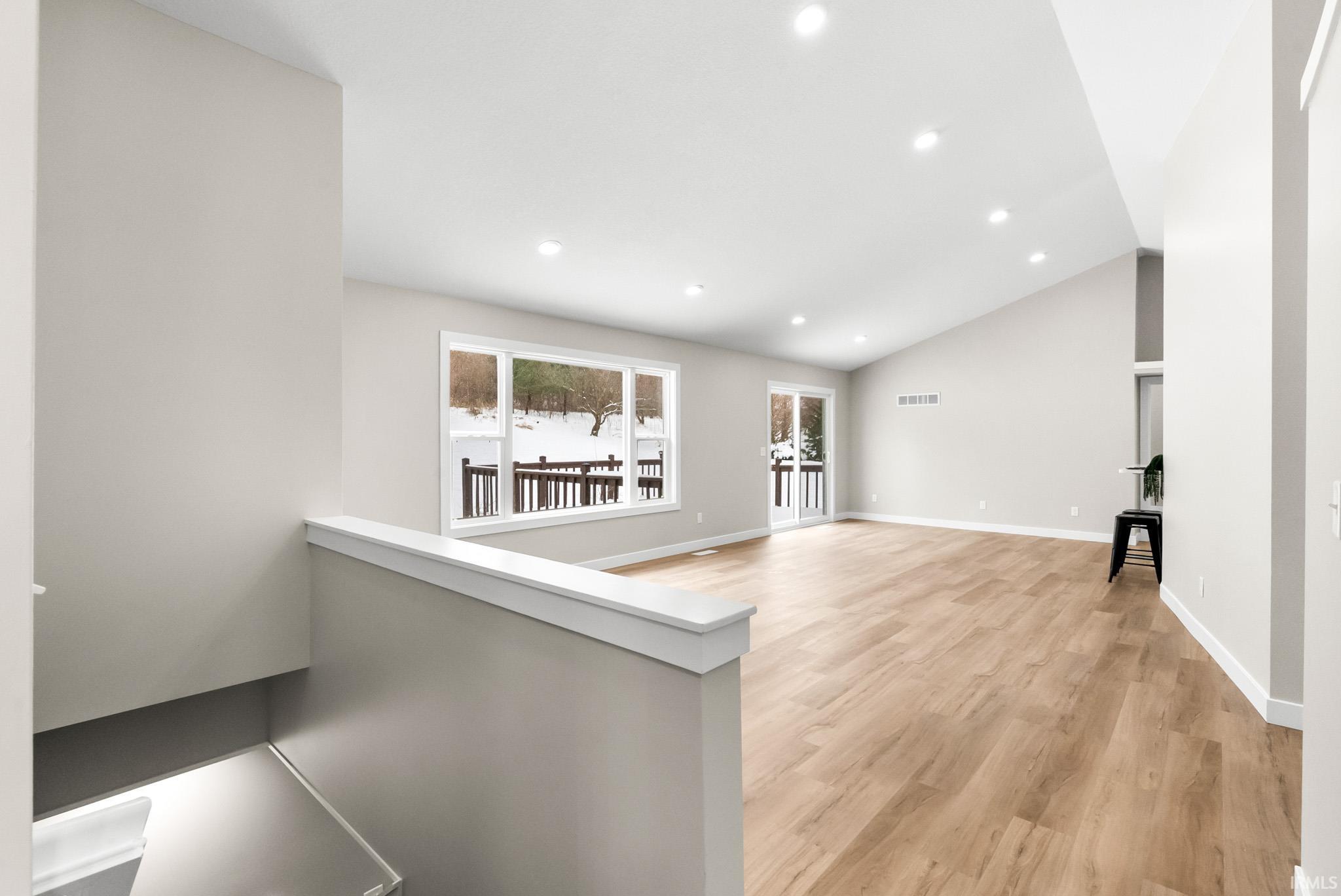 Corridor with recessed lighting, light wood-style flooring, and lofted ceiling