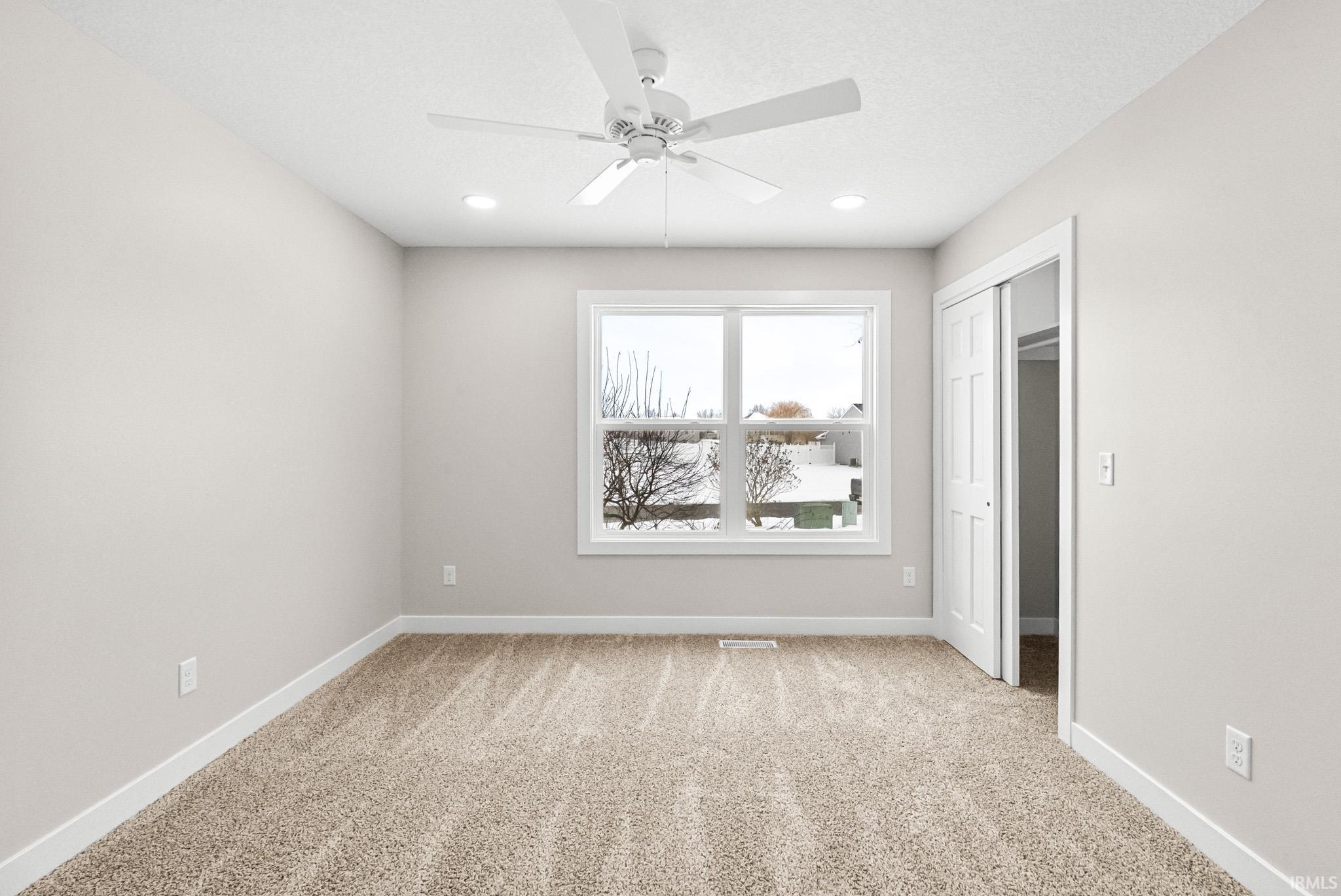 Unfurnished bedroom with a closet, light colored carpet, and ceiling fan