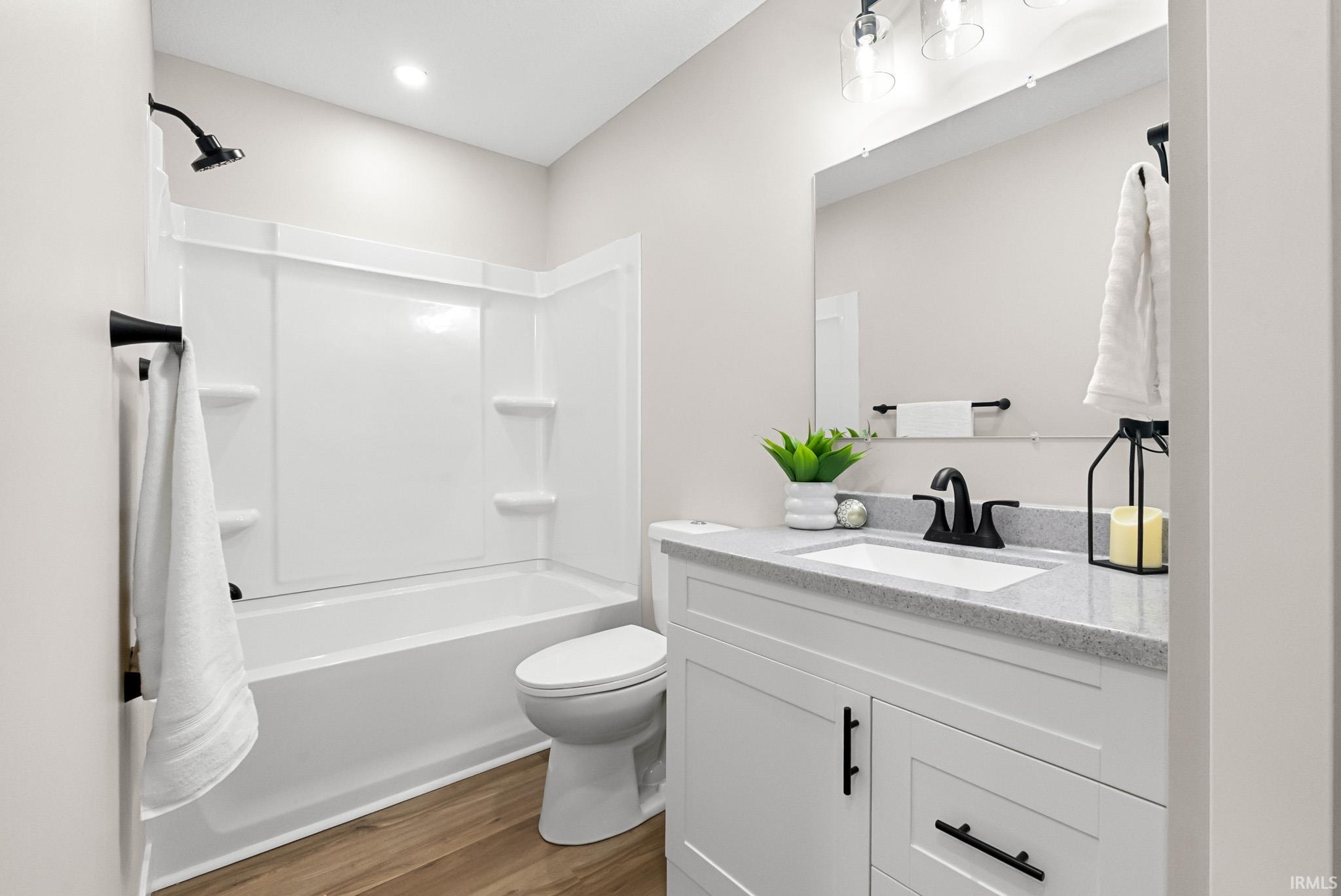 Full bathroom featuring shower / washtub combination, vanity, and dark wood-style flooring