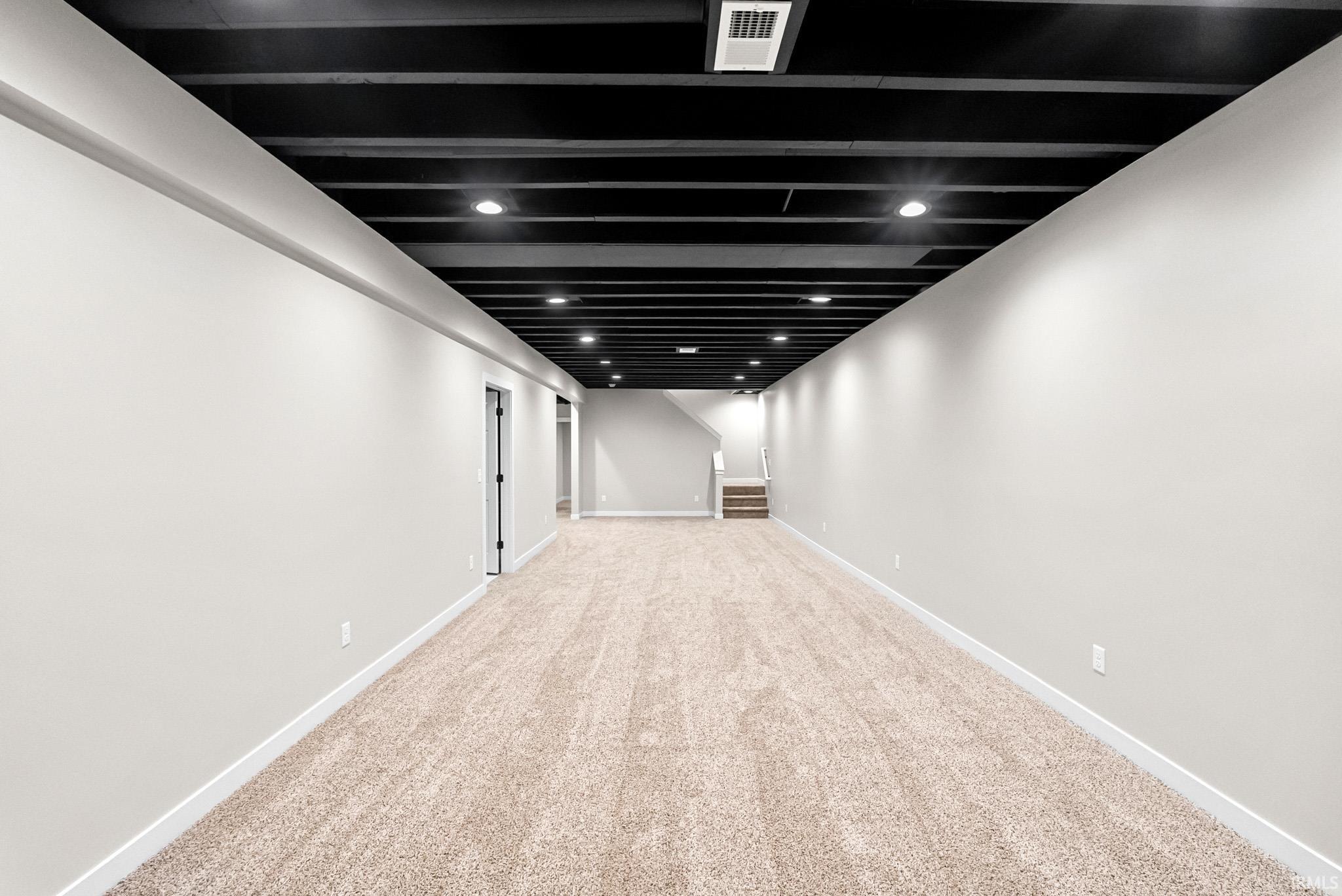 Finished below grade area featuring carpet floors and recessed lighting