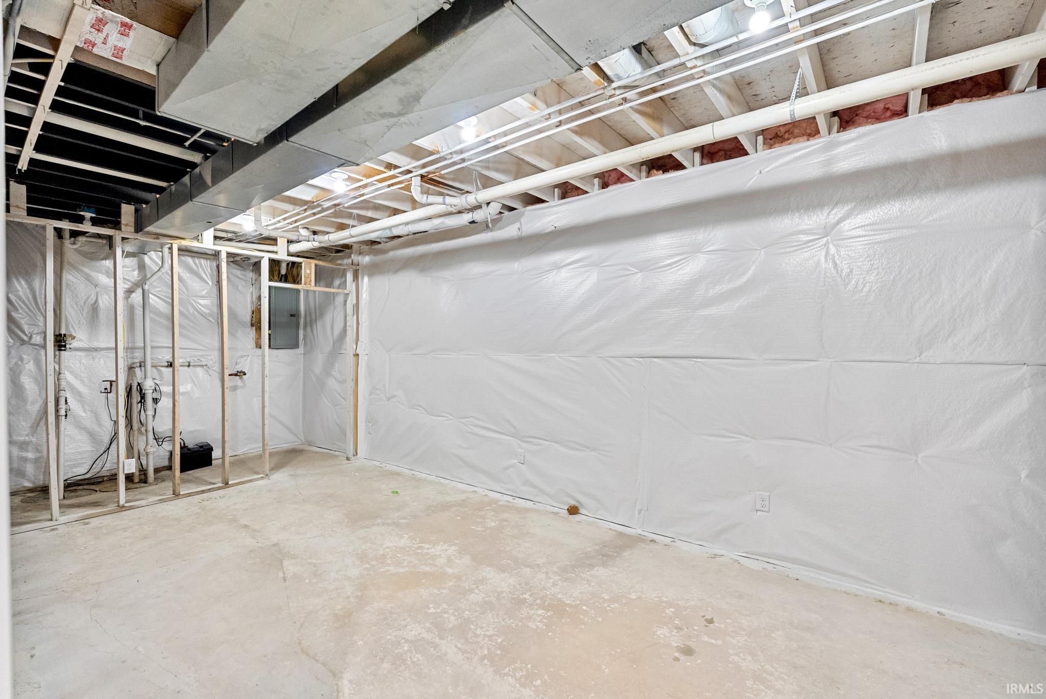 Unfinished basement with electric panel