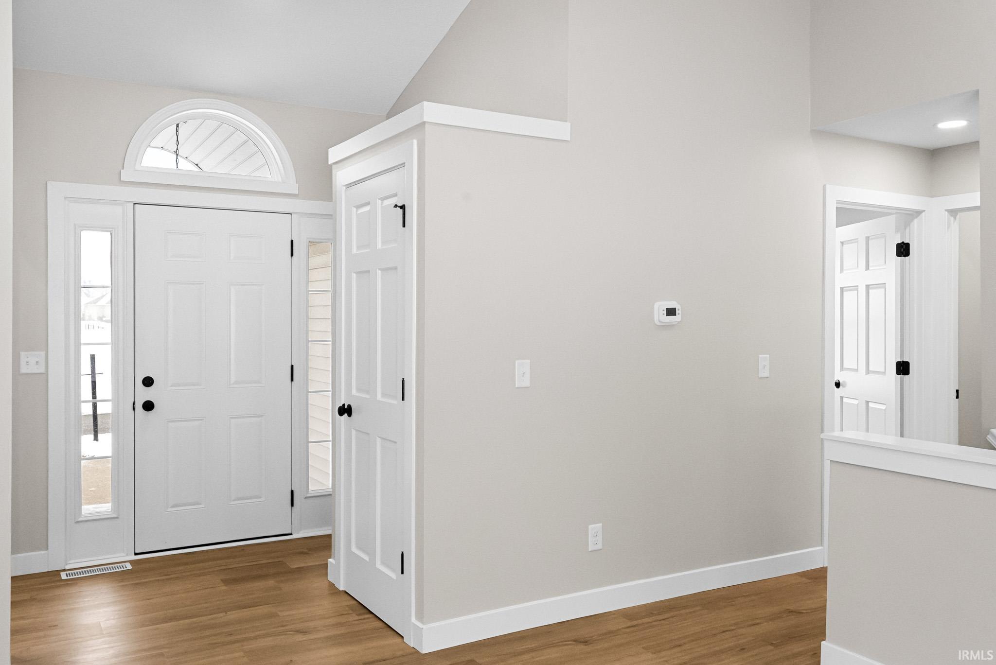 Foyer with light wood finished floors and baseboards