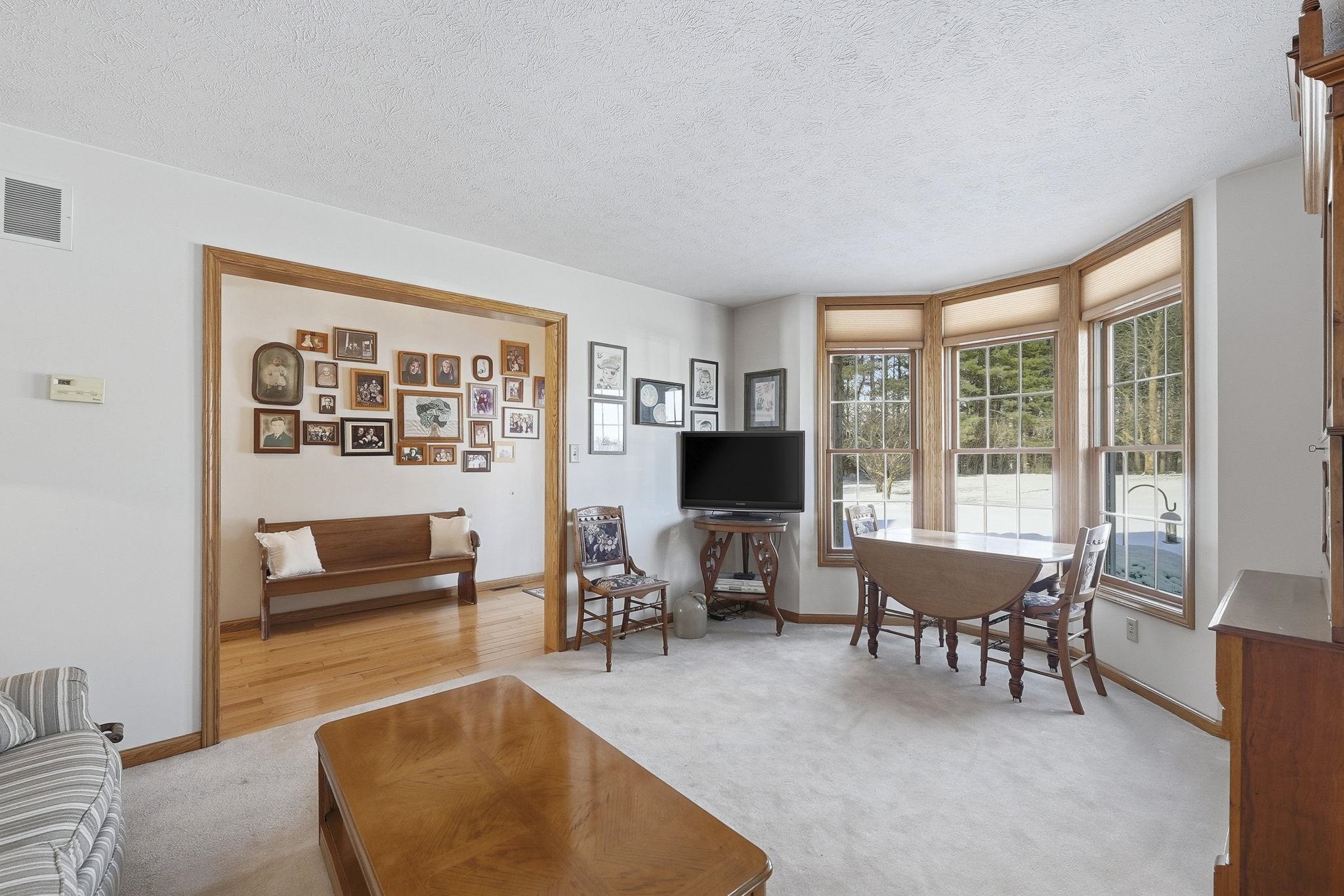 Living area featuring a textured ceiling and light carpet