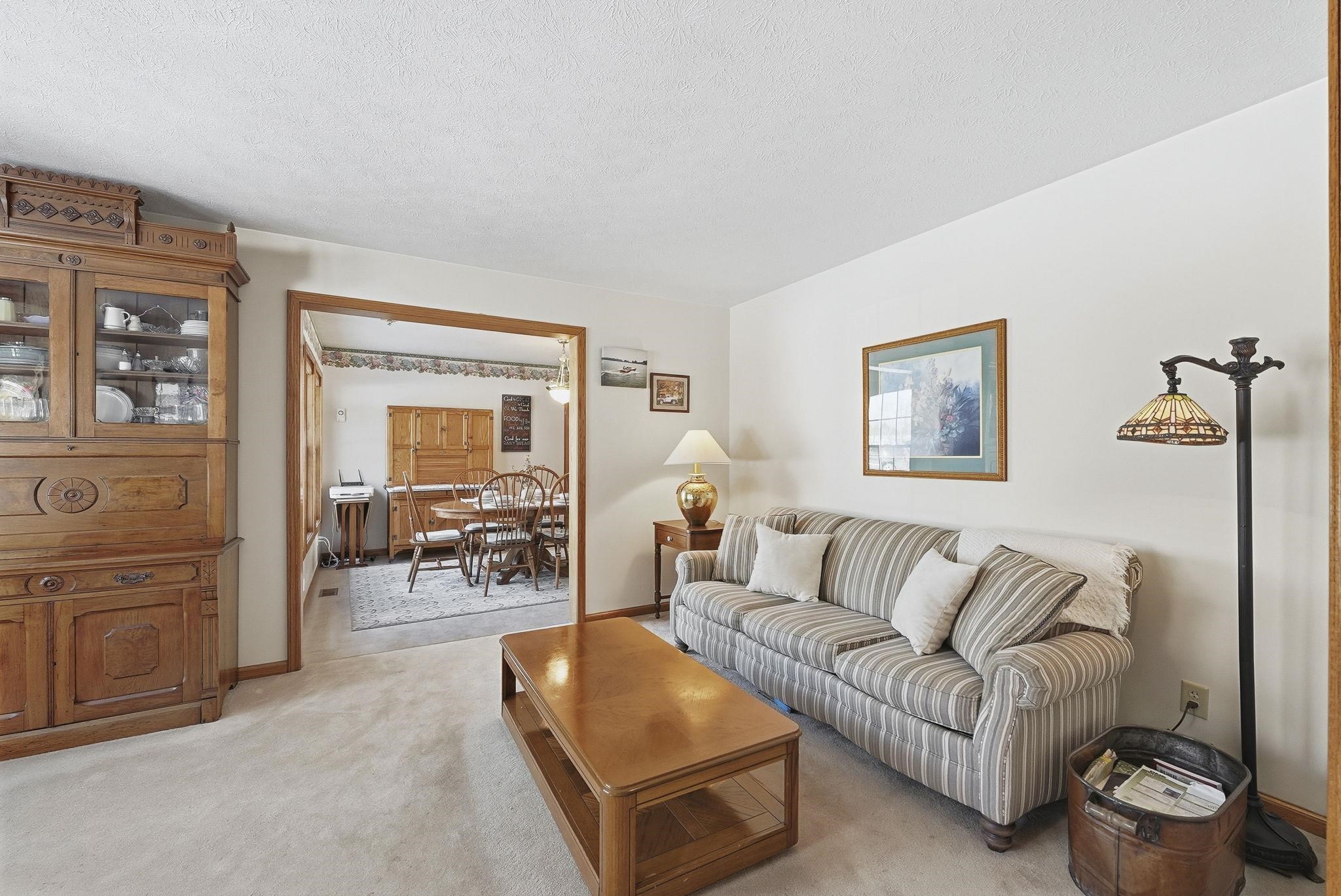 Living room with light colored carpet and a textured ceiling