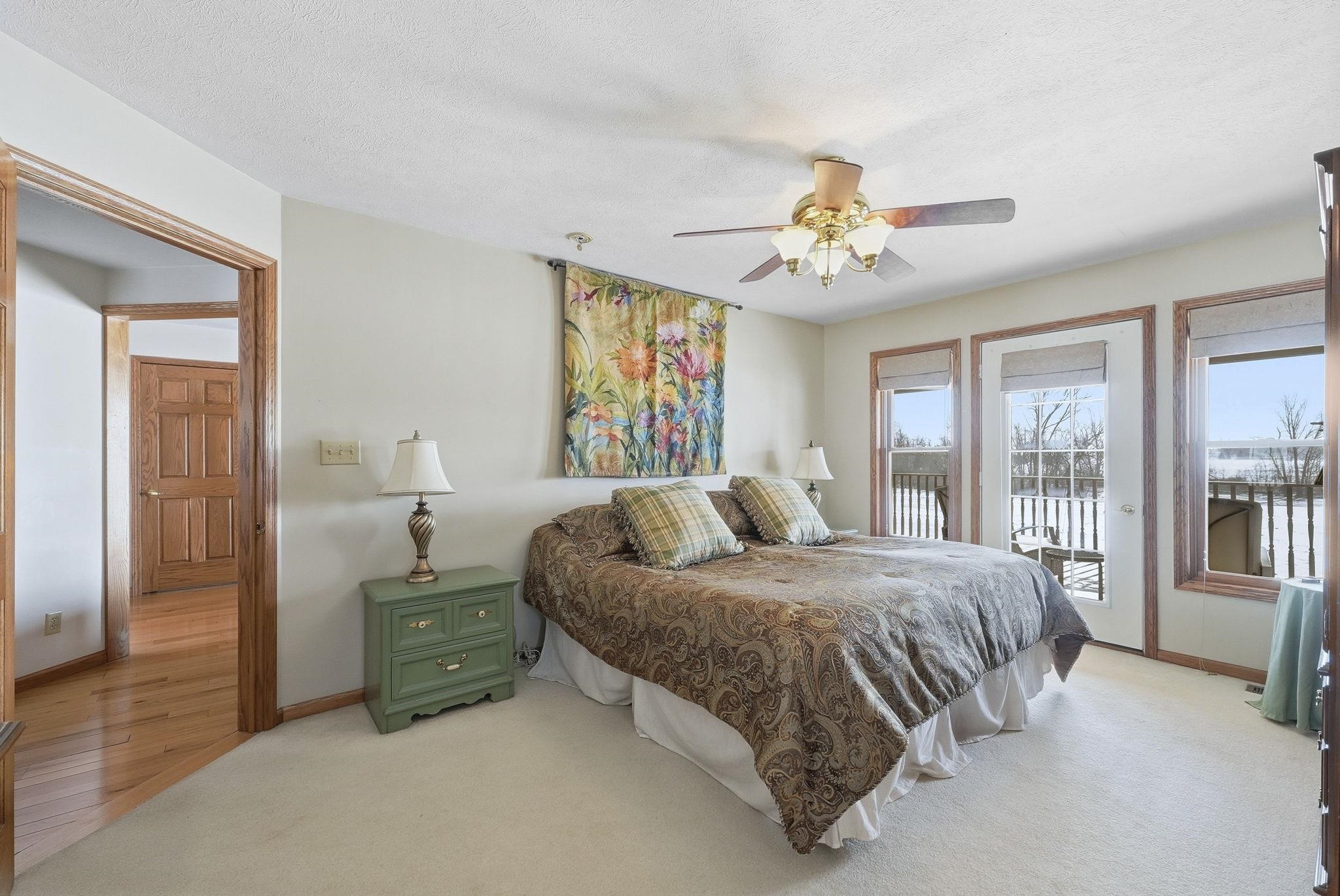 Bedroom with access to outside, carpet flooring, a ceiling fan, and a textured ceiling