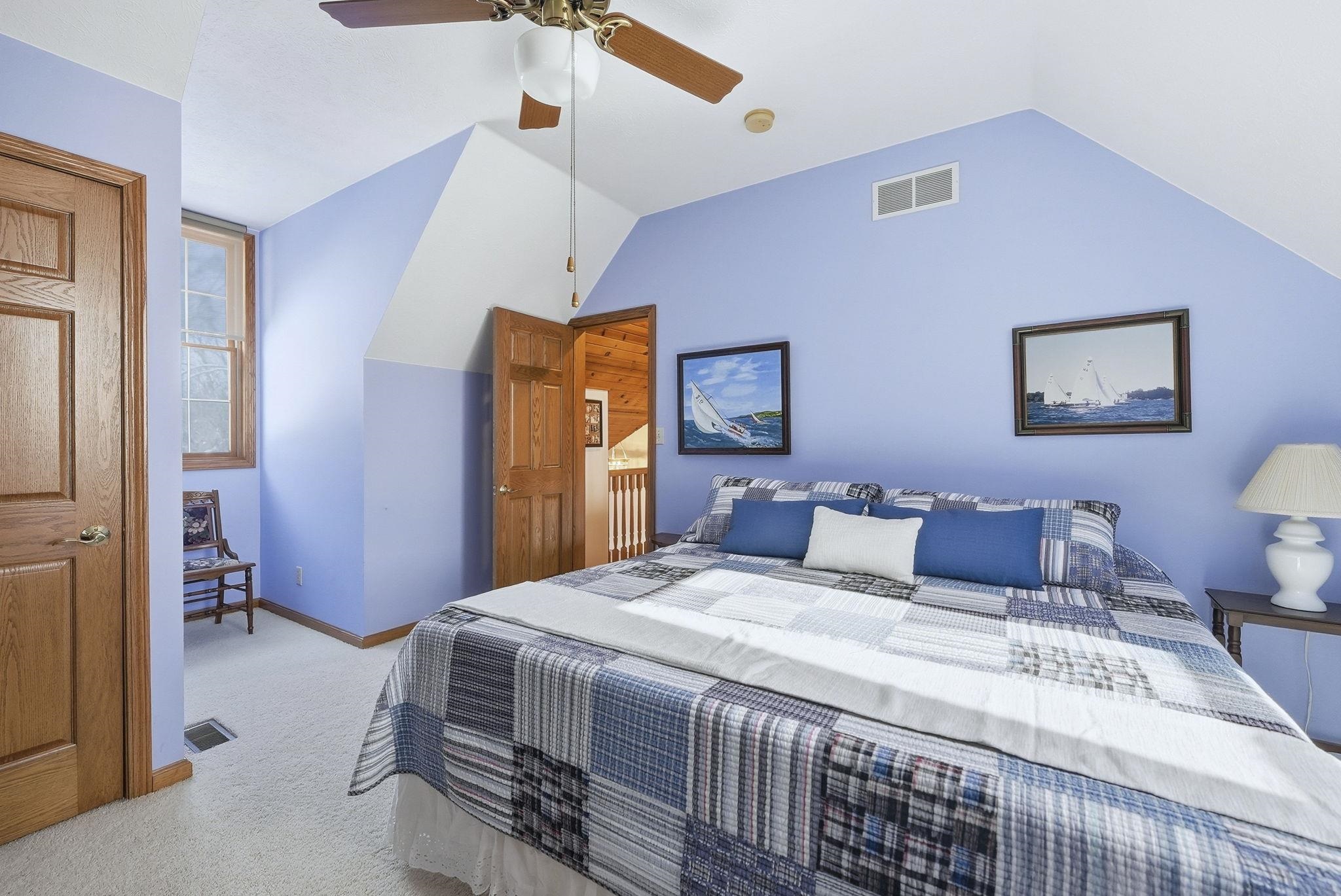 Bedroom featuring ceiling fan, carpet, and vaulted ceiling