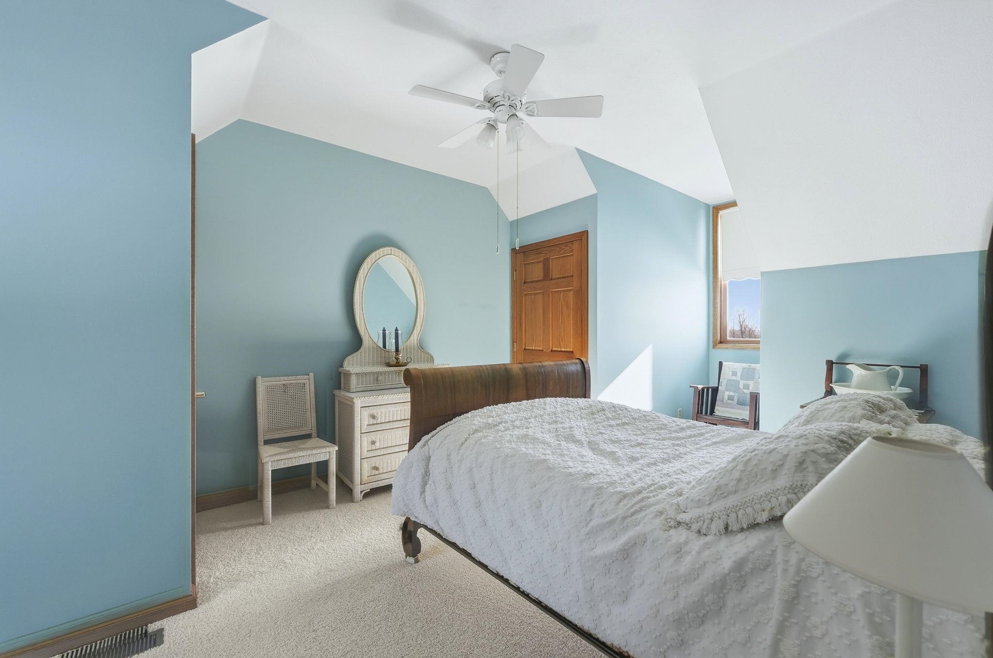 Bedroom with carpet flooring, vaulted ceiling, and ceiling fan