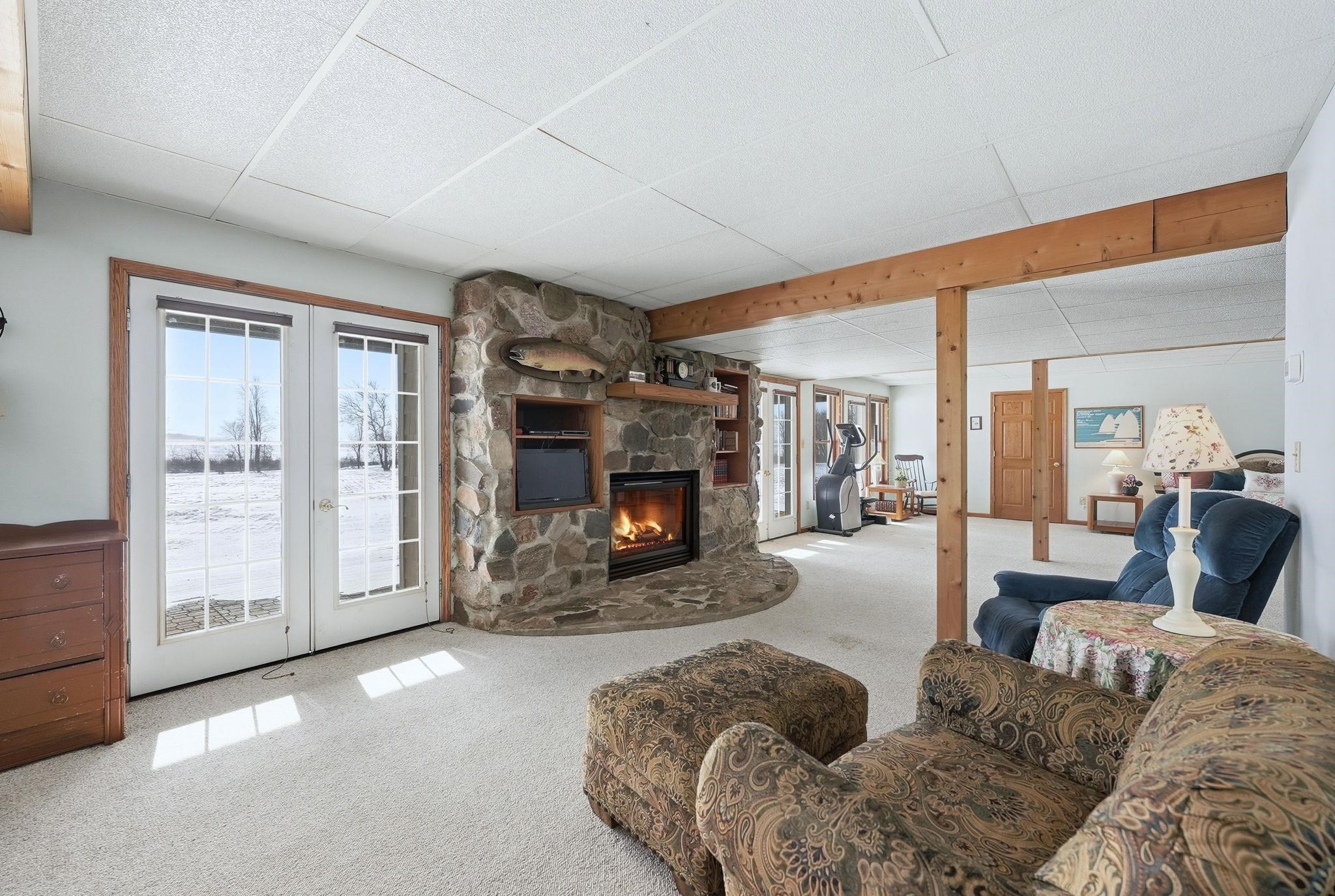 Living area featuring carpet, a fireplace, a paneled ceiling, and french doors