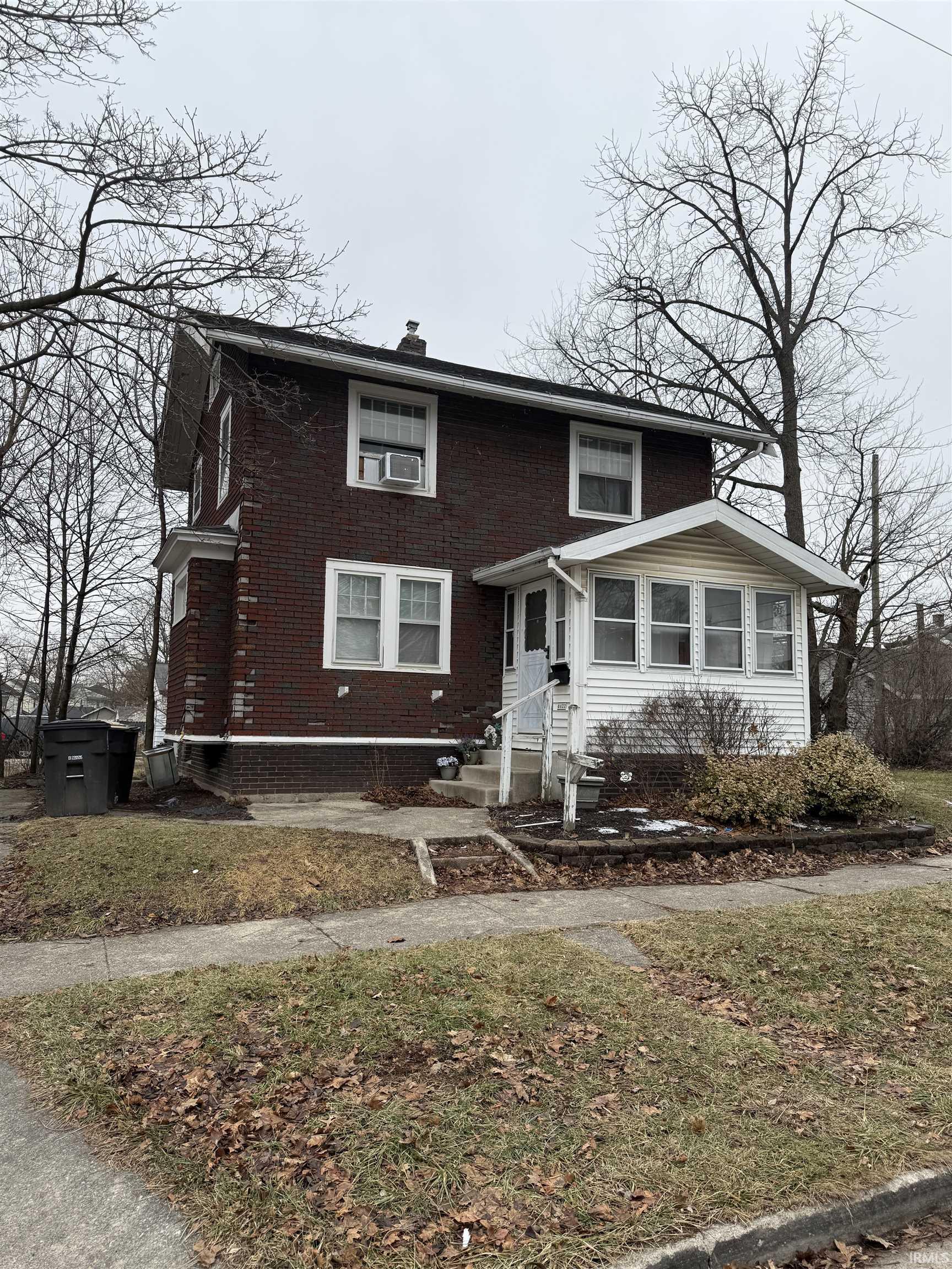 View of front of house featuring brick siding, a chimney, and entry steps