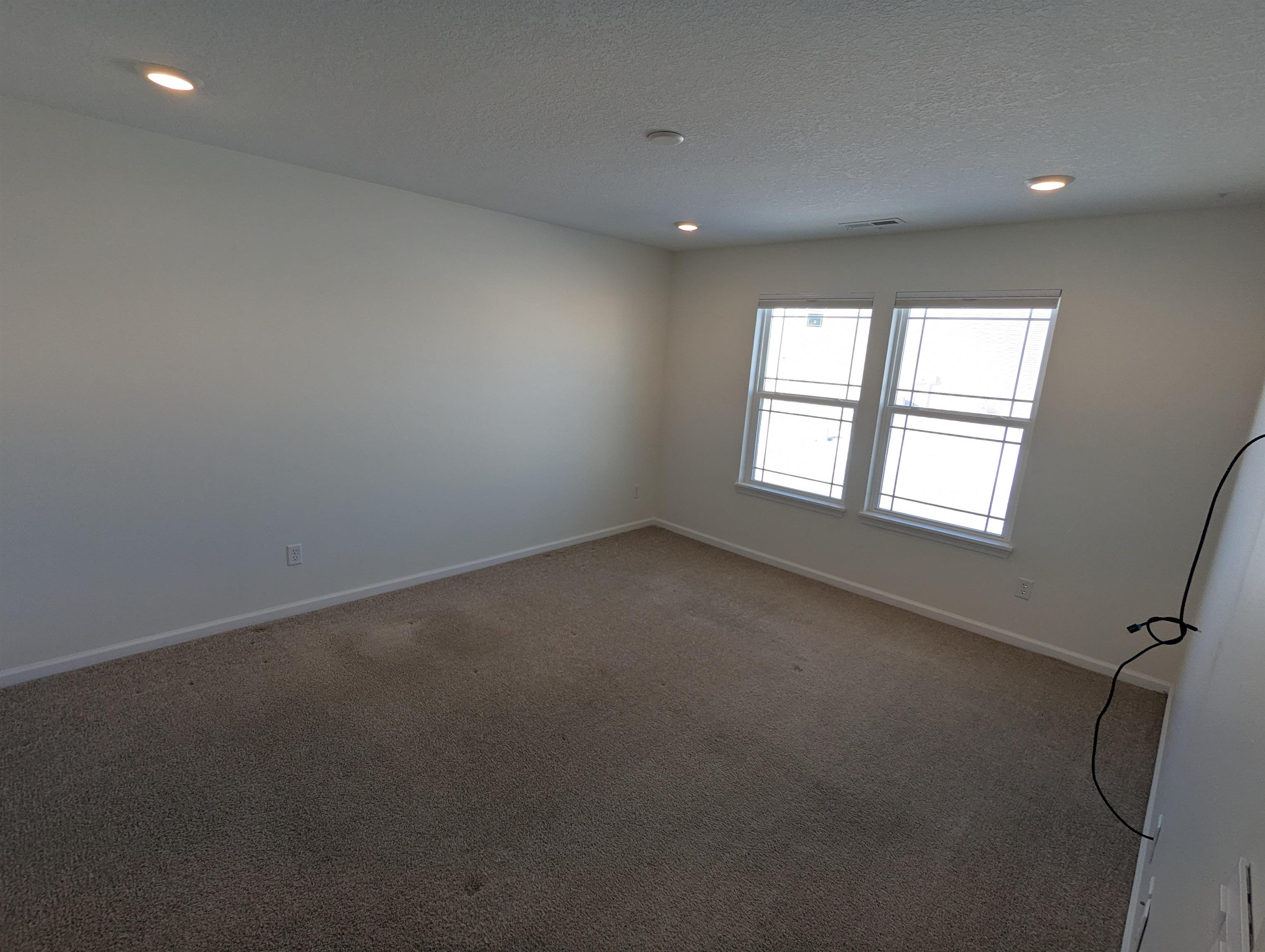 Carpeted empty room with recessed lighting and a textured ceiling